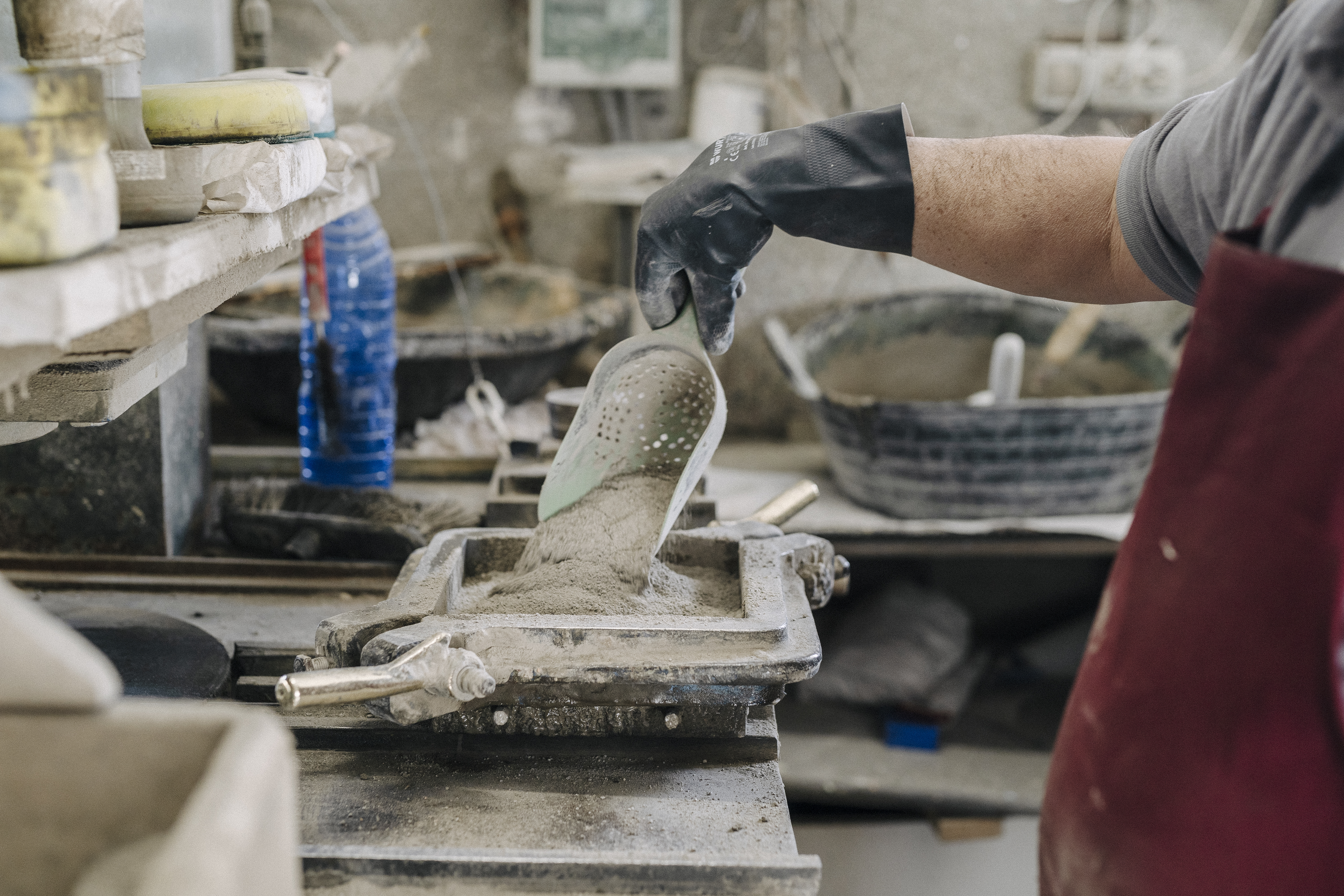 a person holding a scoop of cement