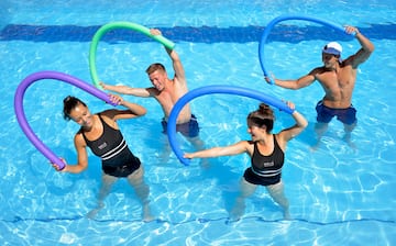 a group of people in a pool holding pool noodles