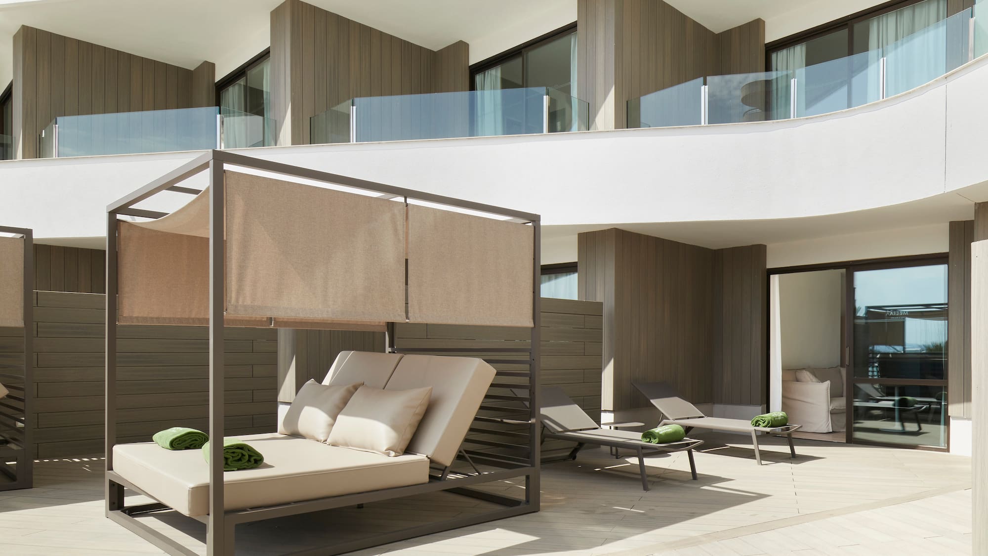 a patio with a bed and chairs