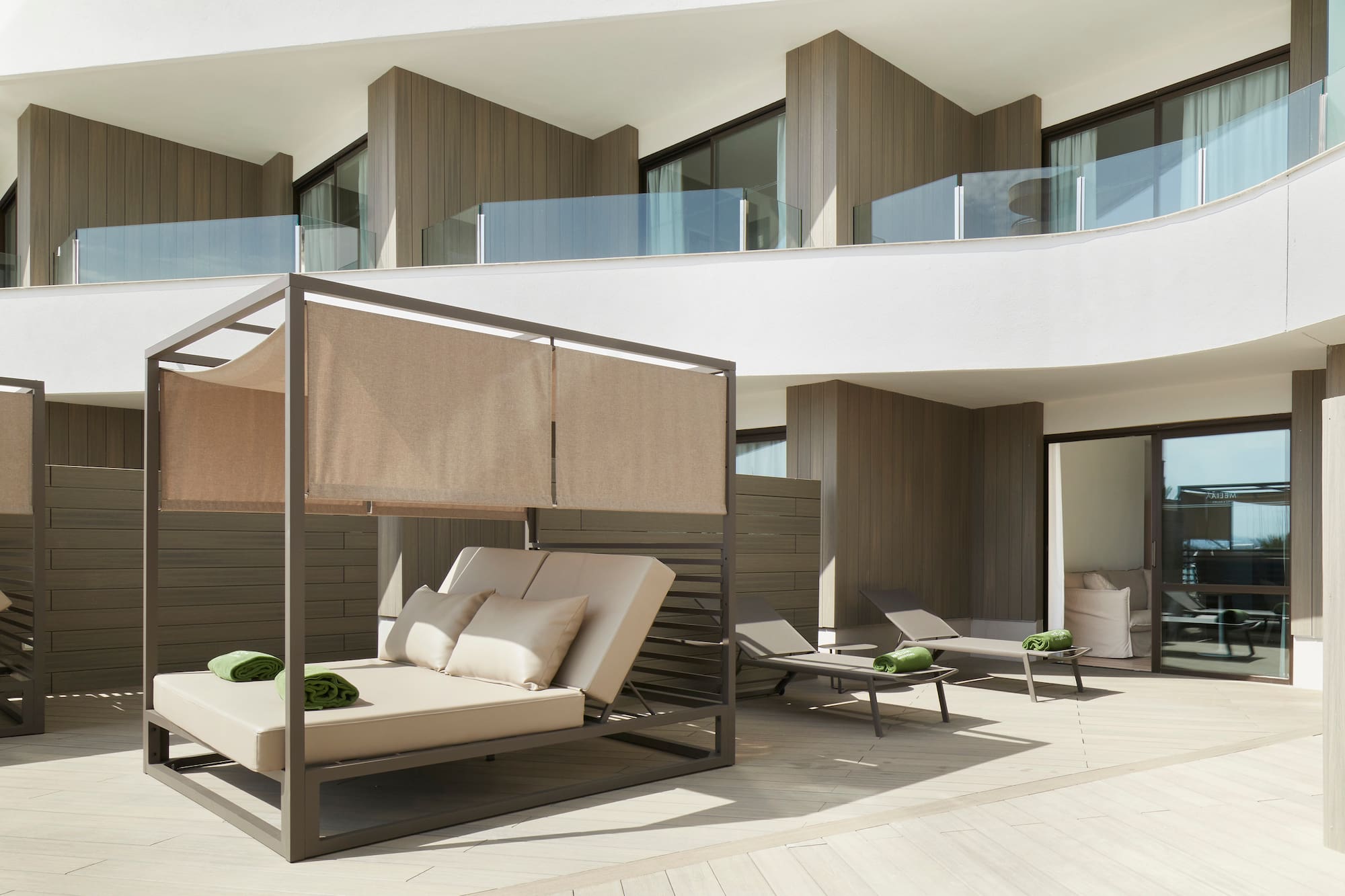 a patio with a bed and chairs