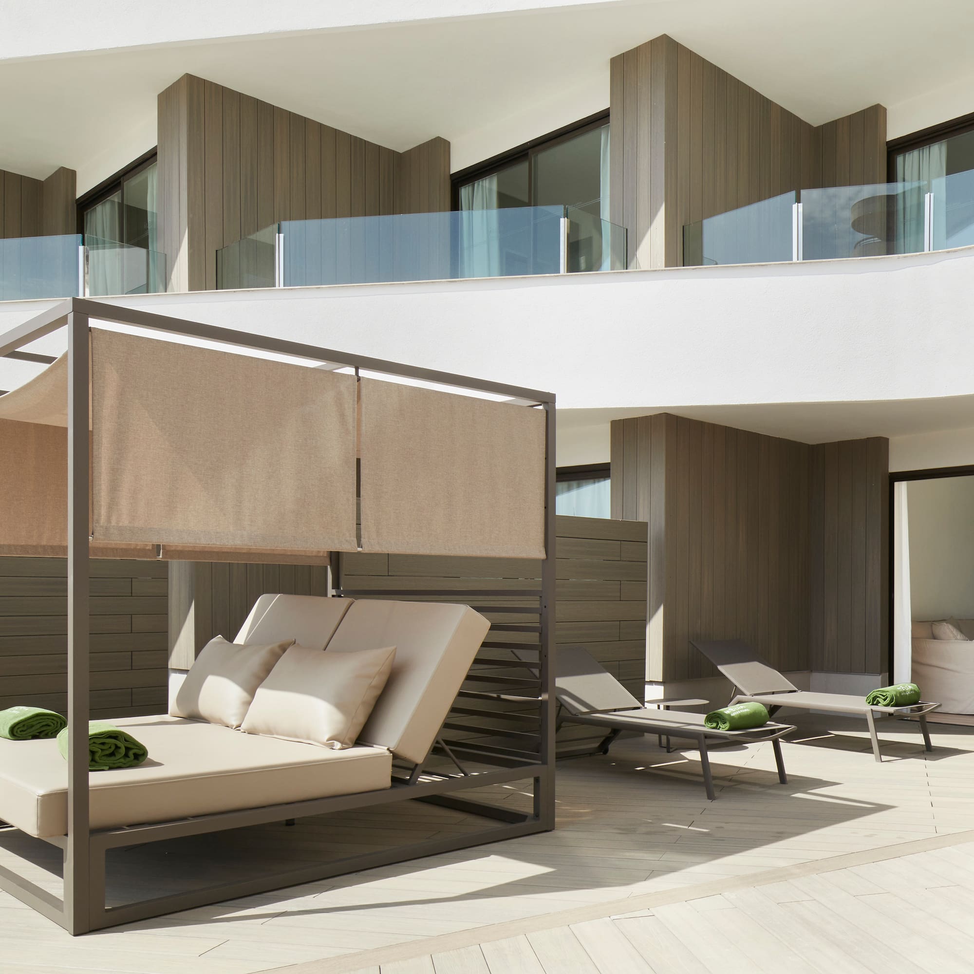 a patio with a bed and chairs