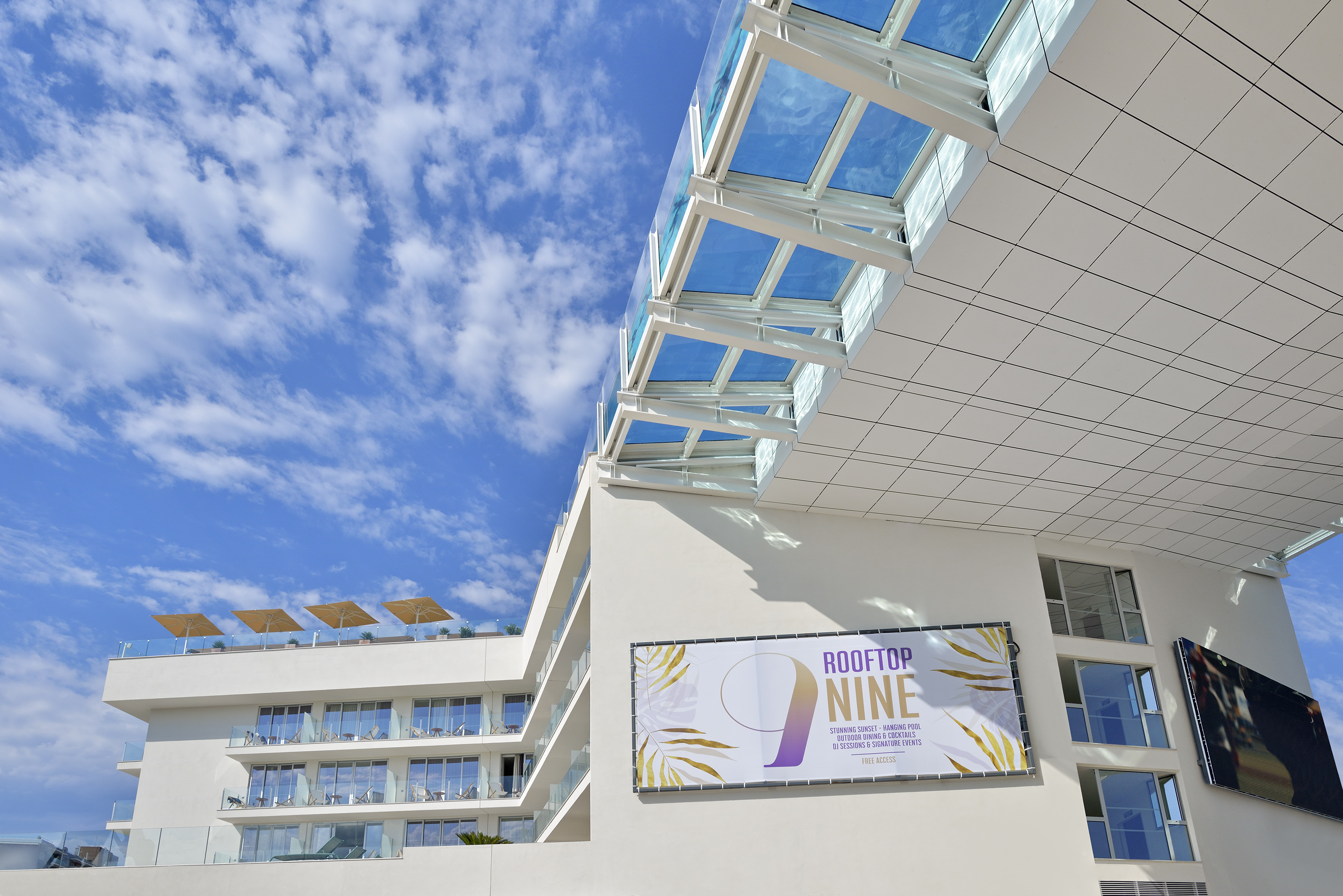 Rooftop Nine modern hotel with glass canopy, balconies, and pool.