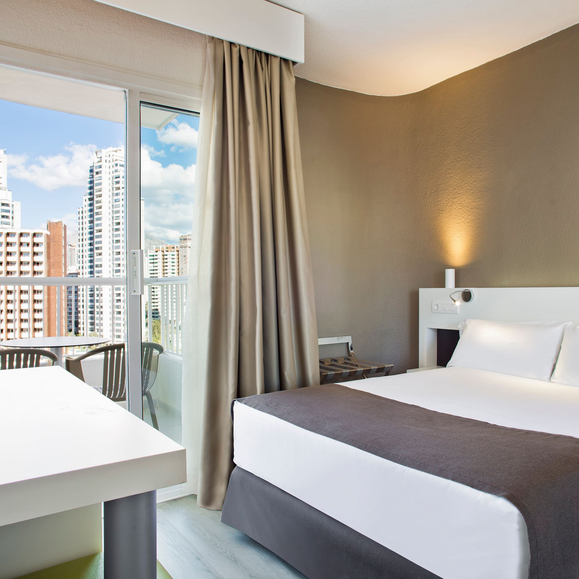 a room with a bed and a table and chairs