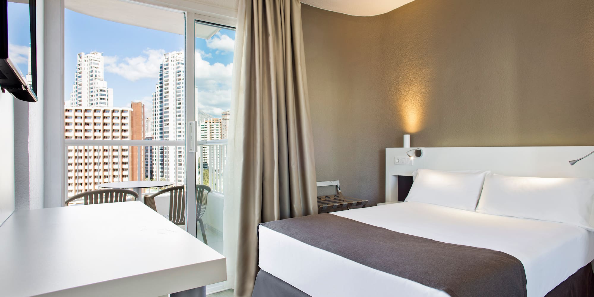 a room with a bed and a table and chairs