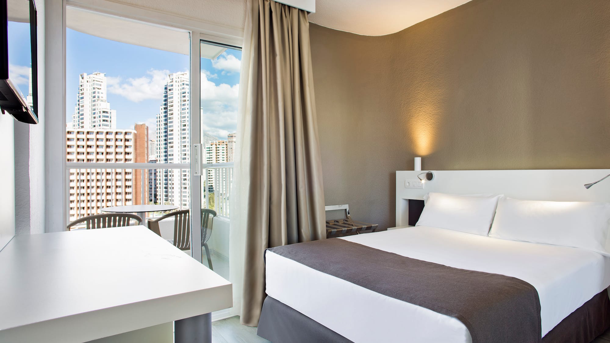 a room with a bed and a table and chairs