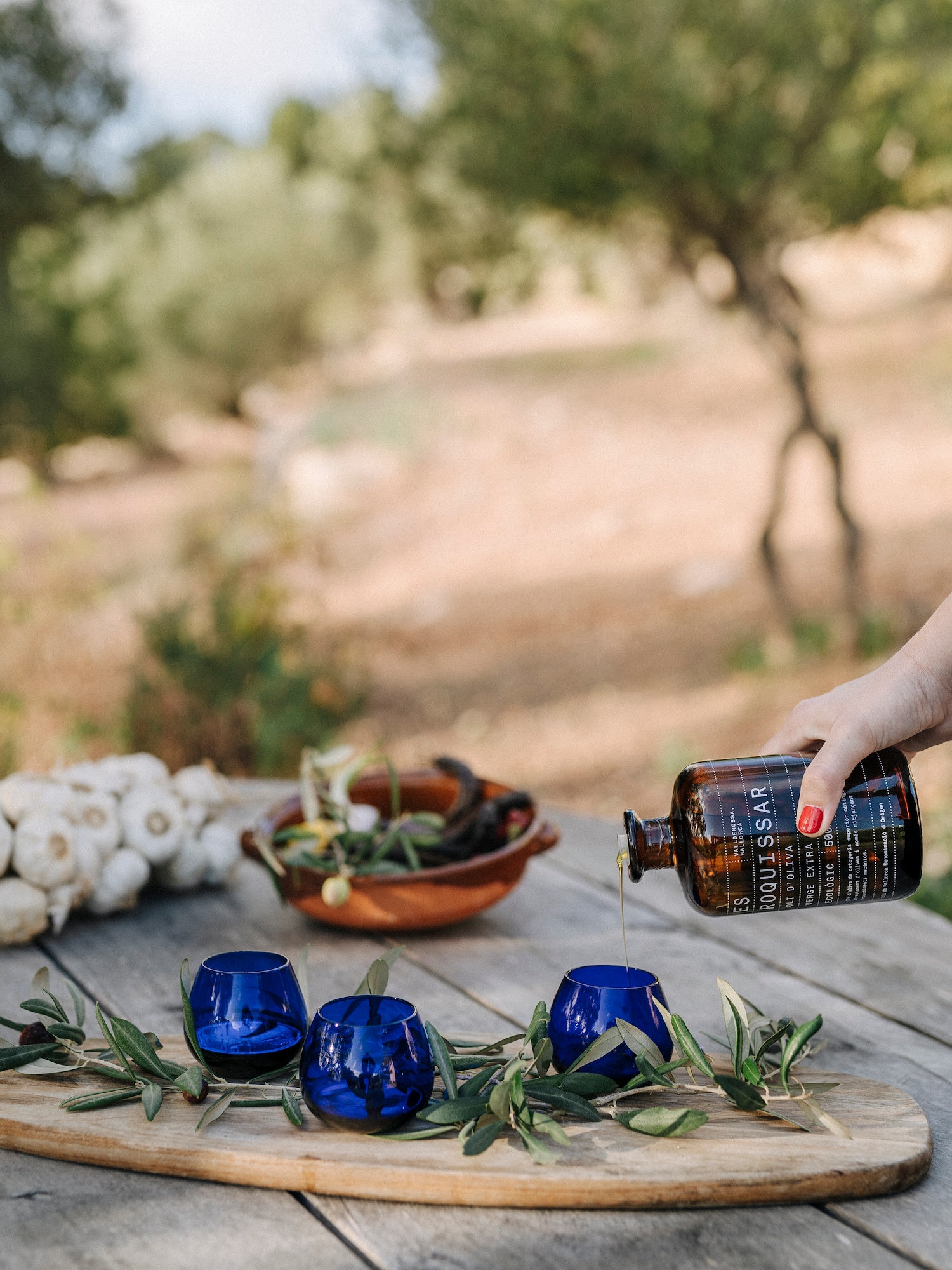 a person pouring a bottle into blue cups