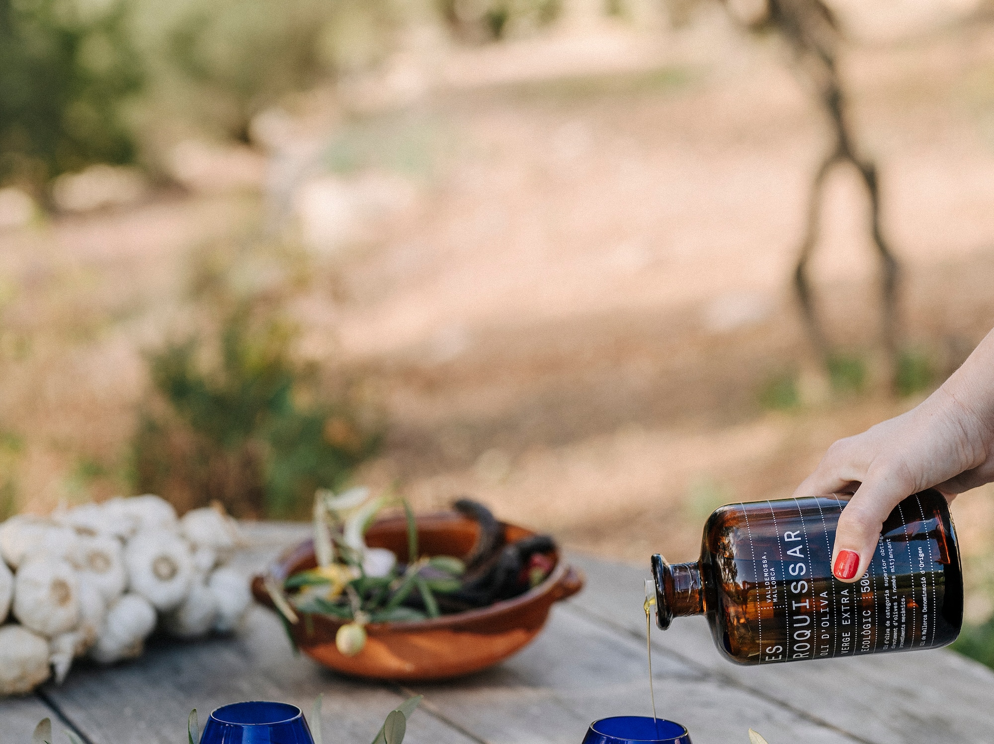 a person pouring a bottle into blue cups
