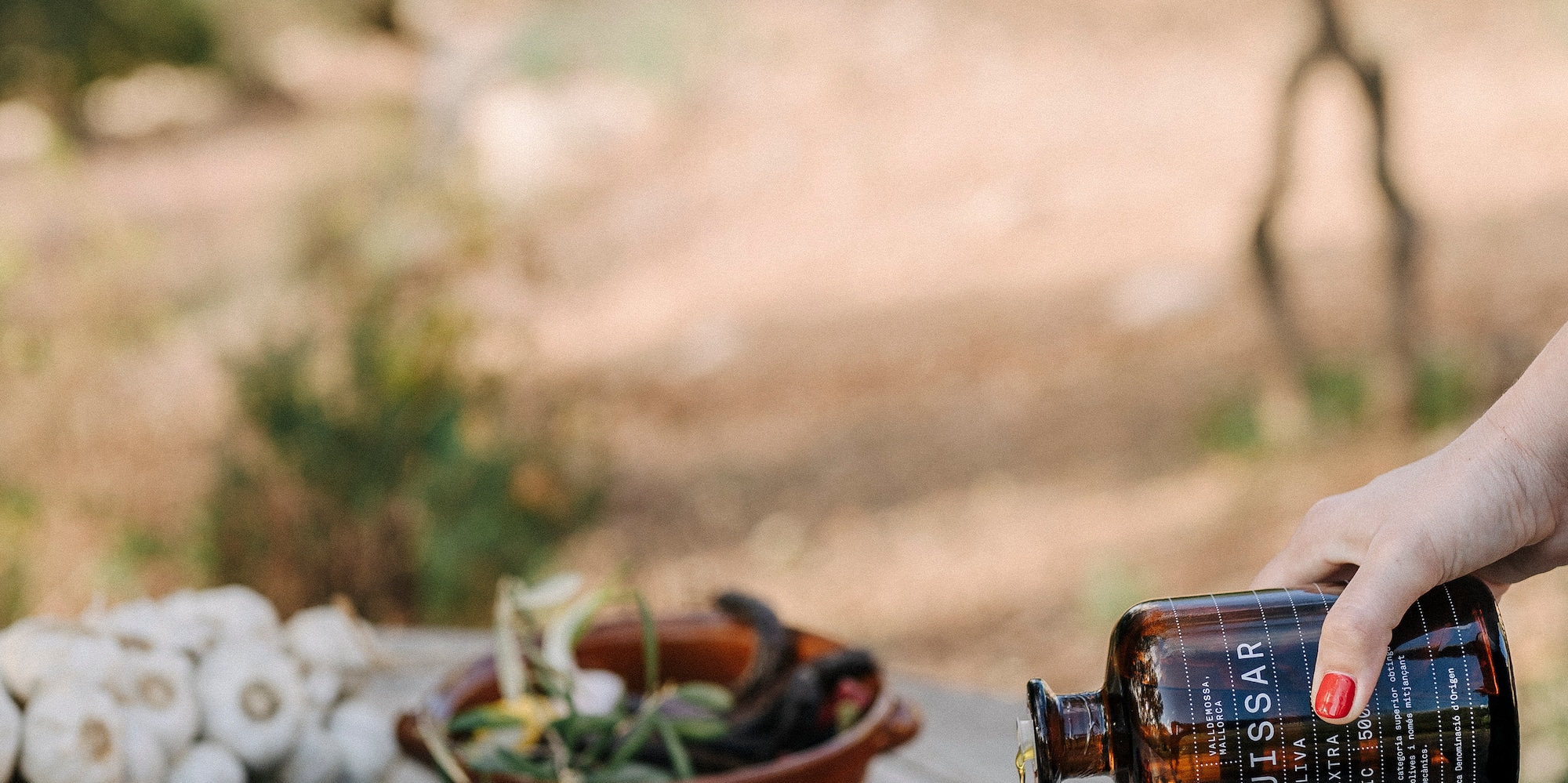 a person pouring a bottle into blue cups