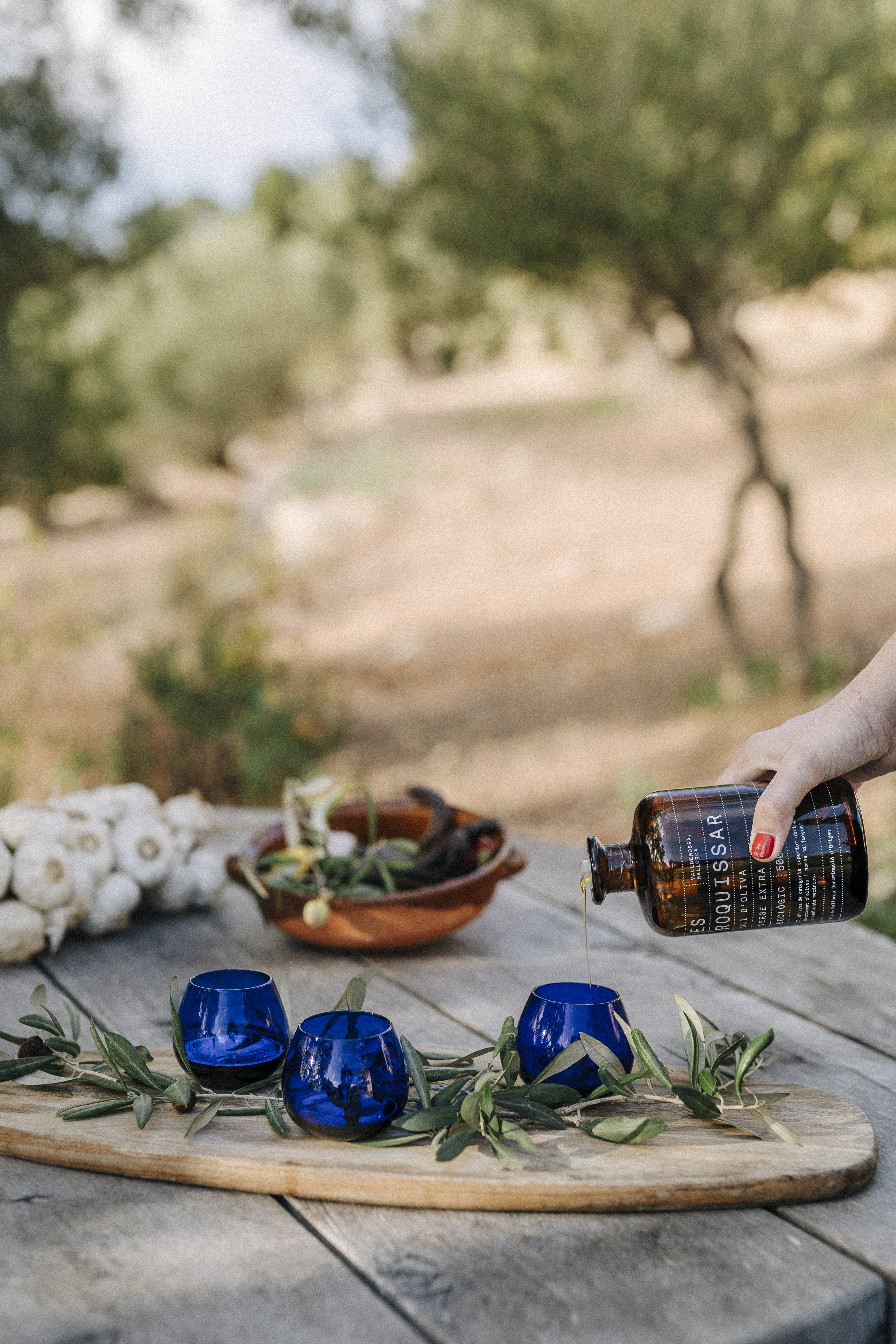 a person pouring a bottle into blue cups