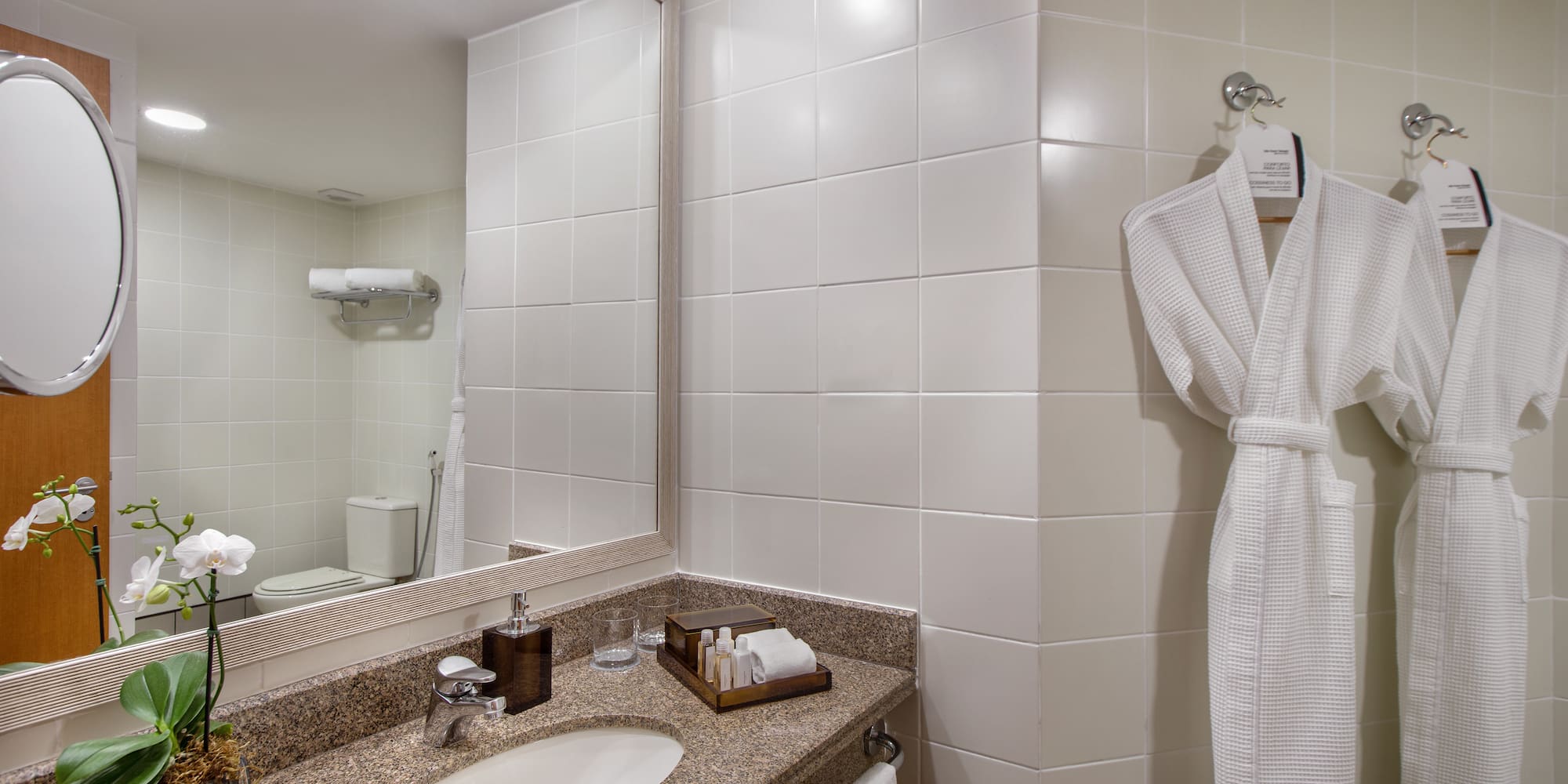 a bathroom with a white bathrobe and a mirror