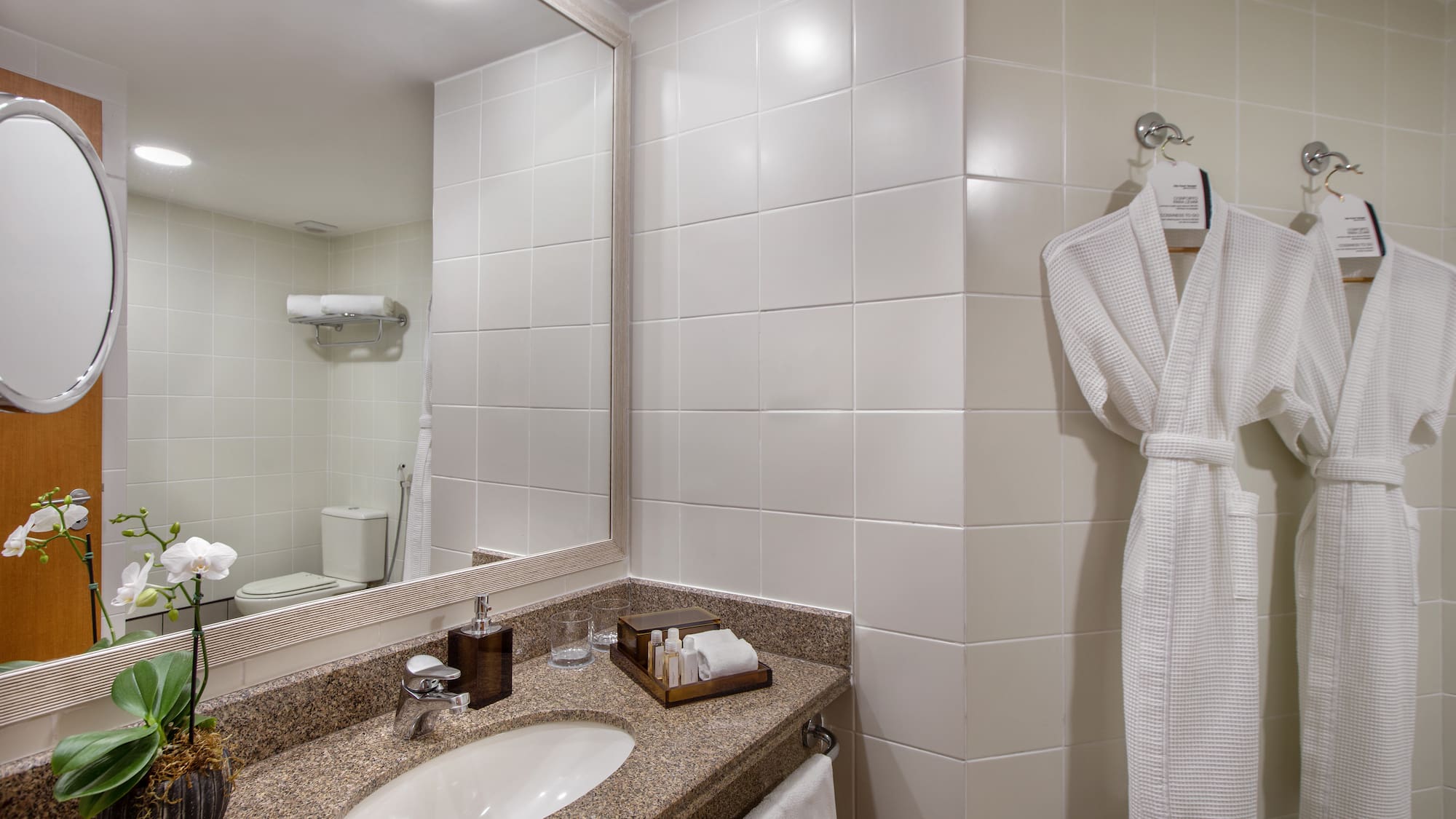 a bathroom with a white bathrobe and a mirror