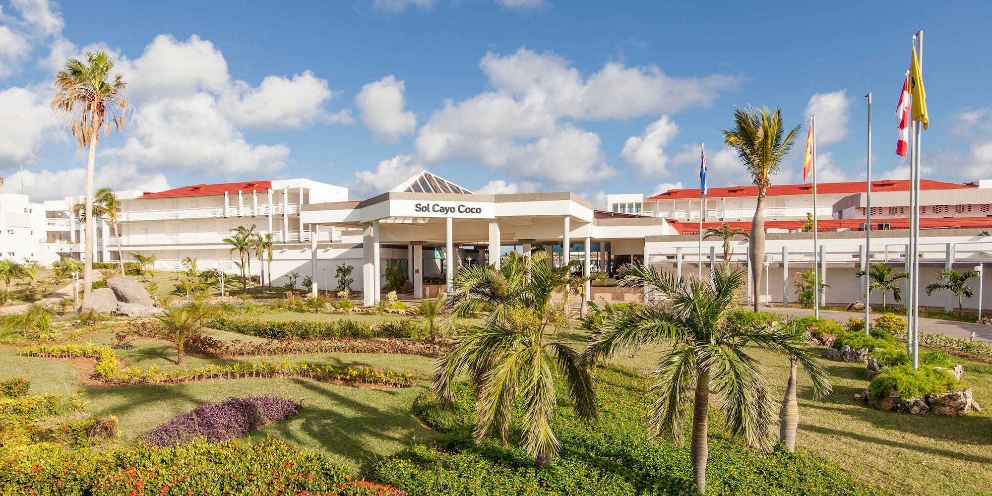 a building with palm trees and a lawn
