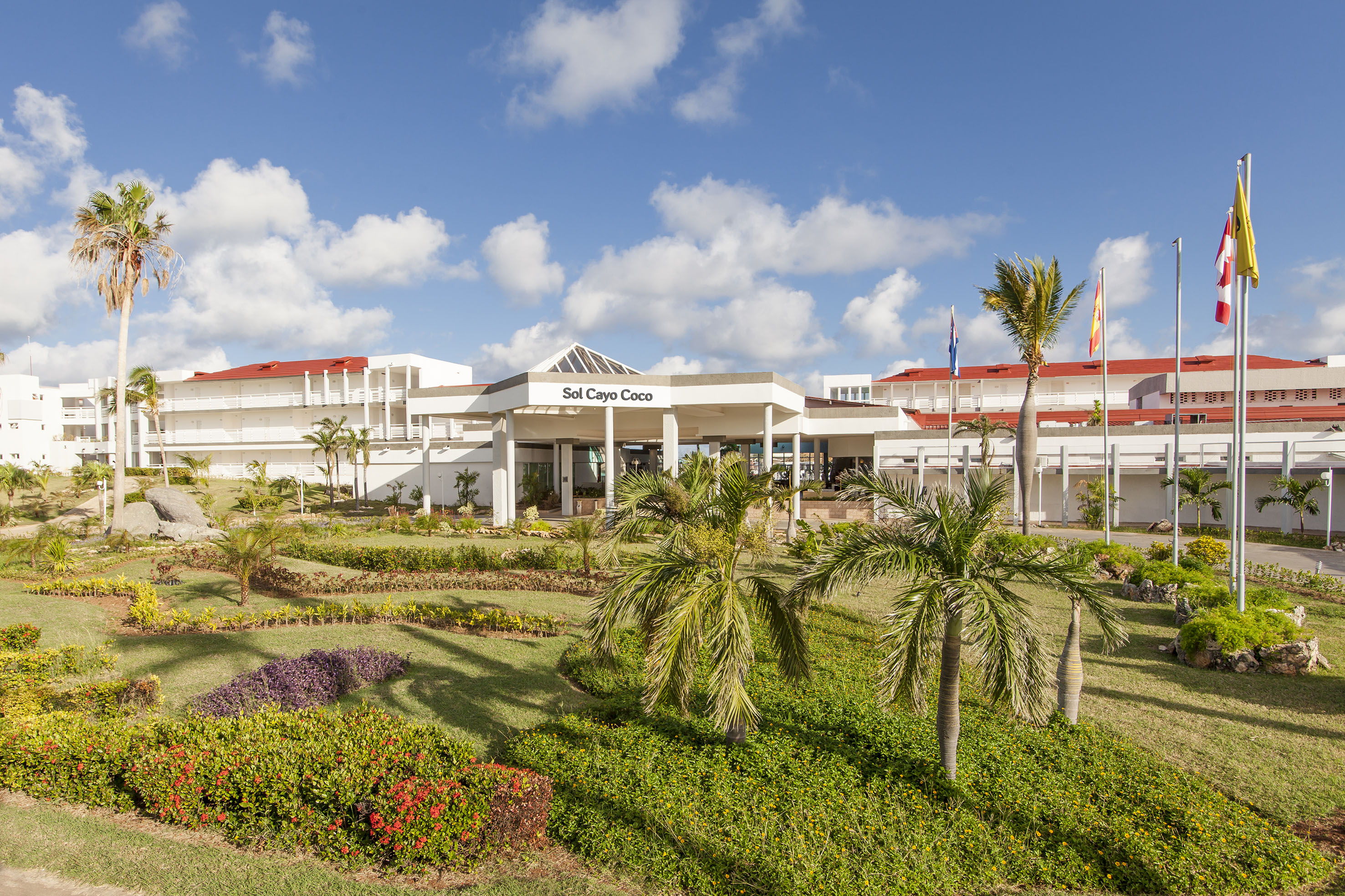 a building with palm trees and a lawn