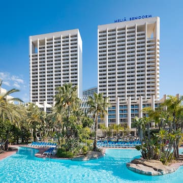 a pool with palm trees and buildings