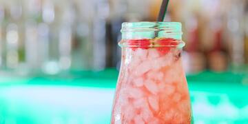 a glass jar with a drink and a straw