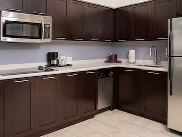 a kitchen with dark wood cabinets and a microwave