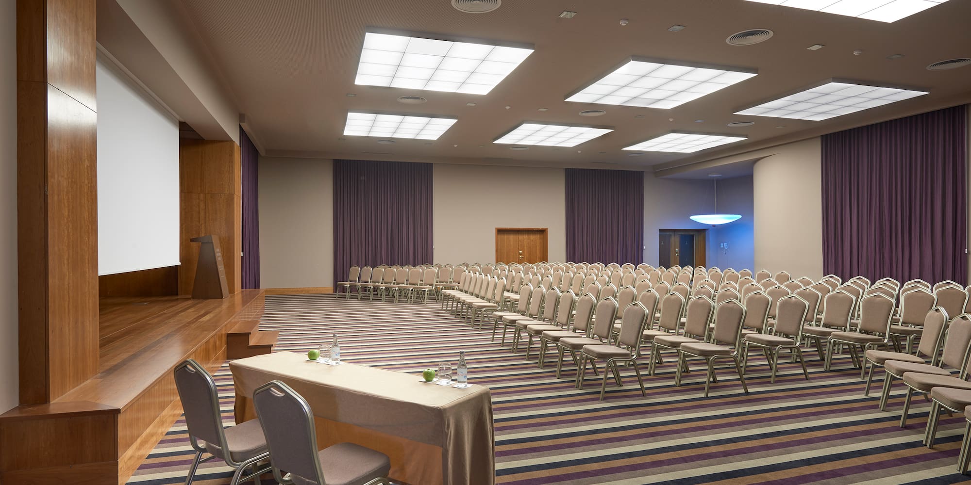 a room with a large screen and chairs