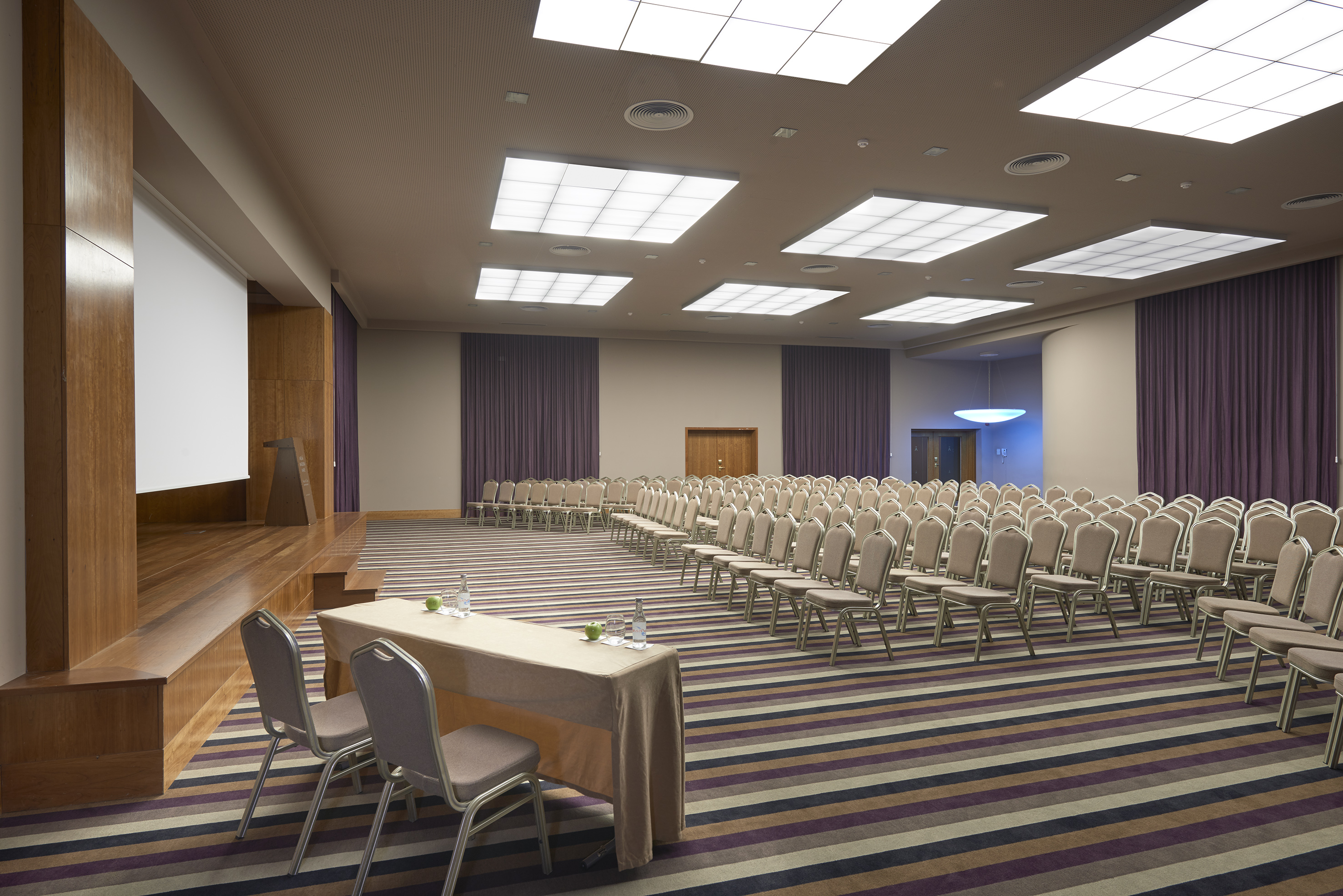 a room with a large screen and chairs