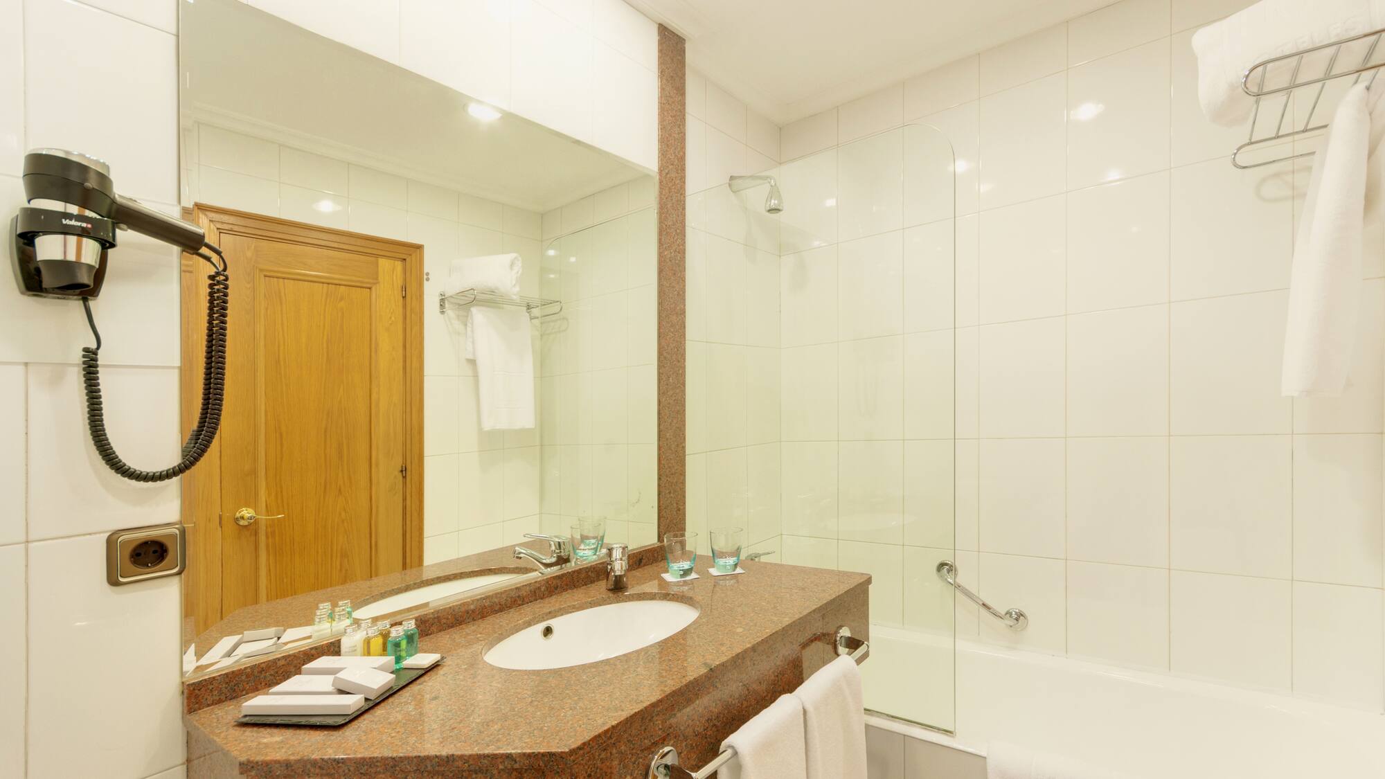 a bathroom with a marble countertop and a shower