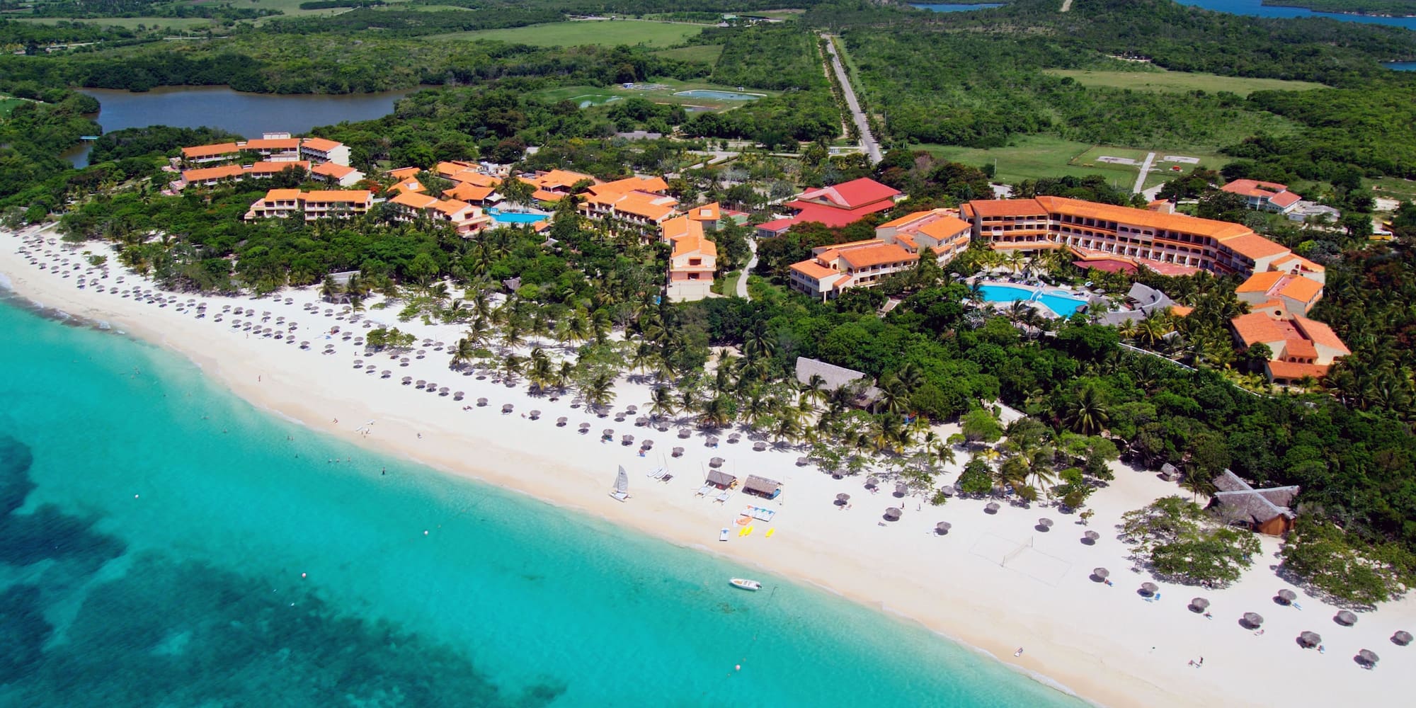 a beach with buildings and trees