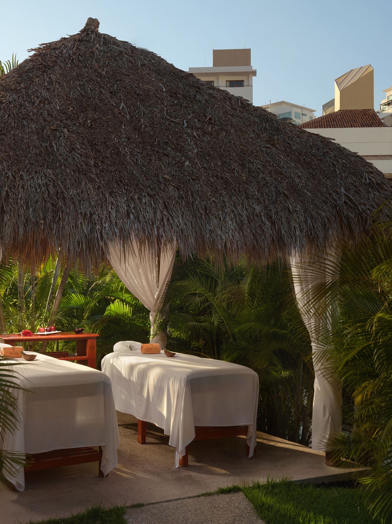 a massage tables under a straw hut