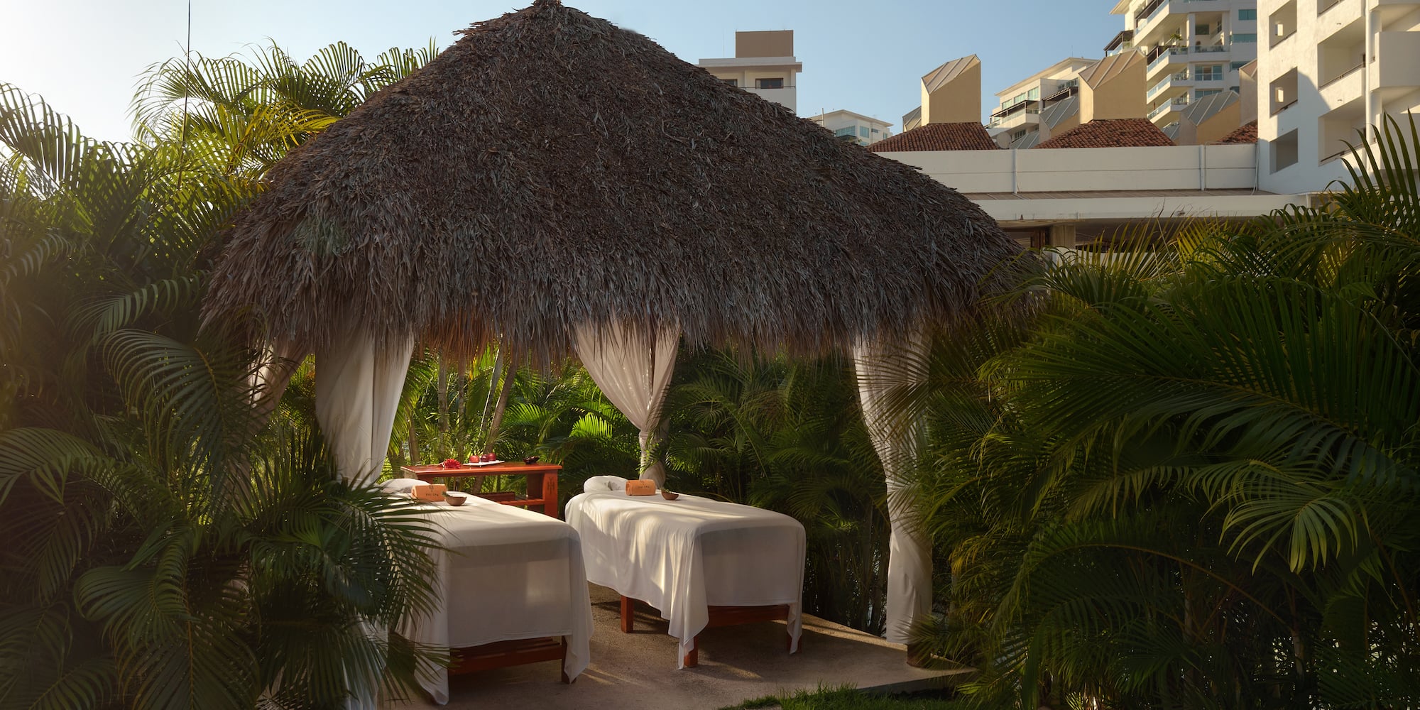 a massage tables under a straw hut