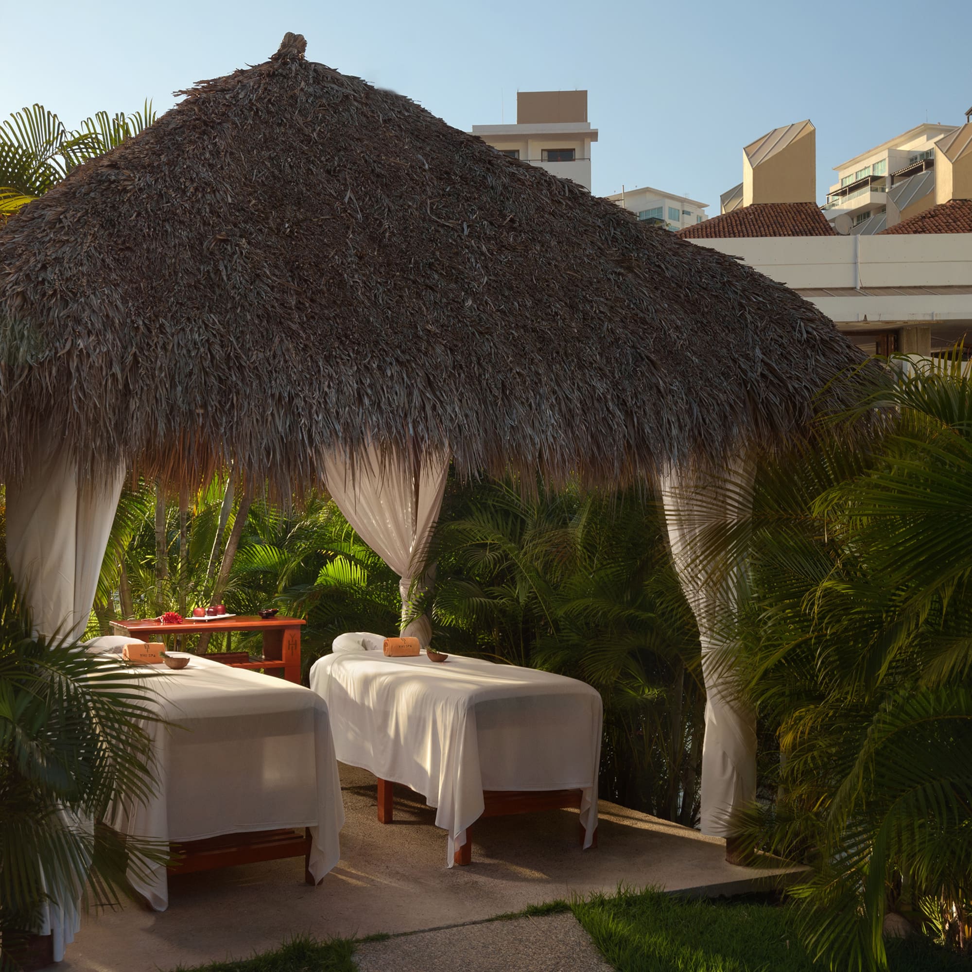 a massage tables under a straw hut