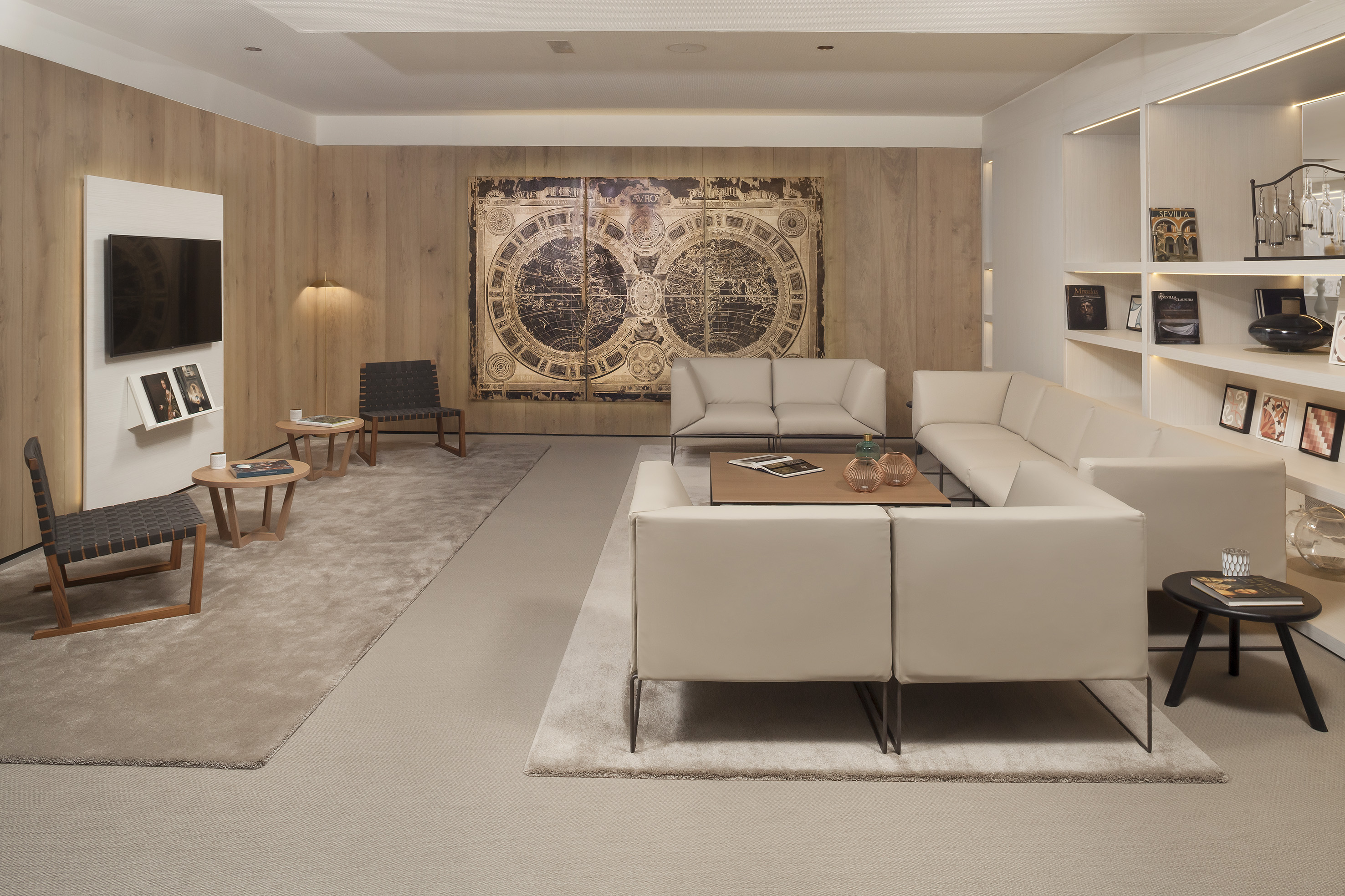 Modern living room with beige sofas, wood walls, and large vintage world map.