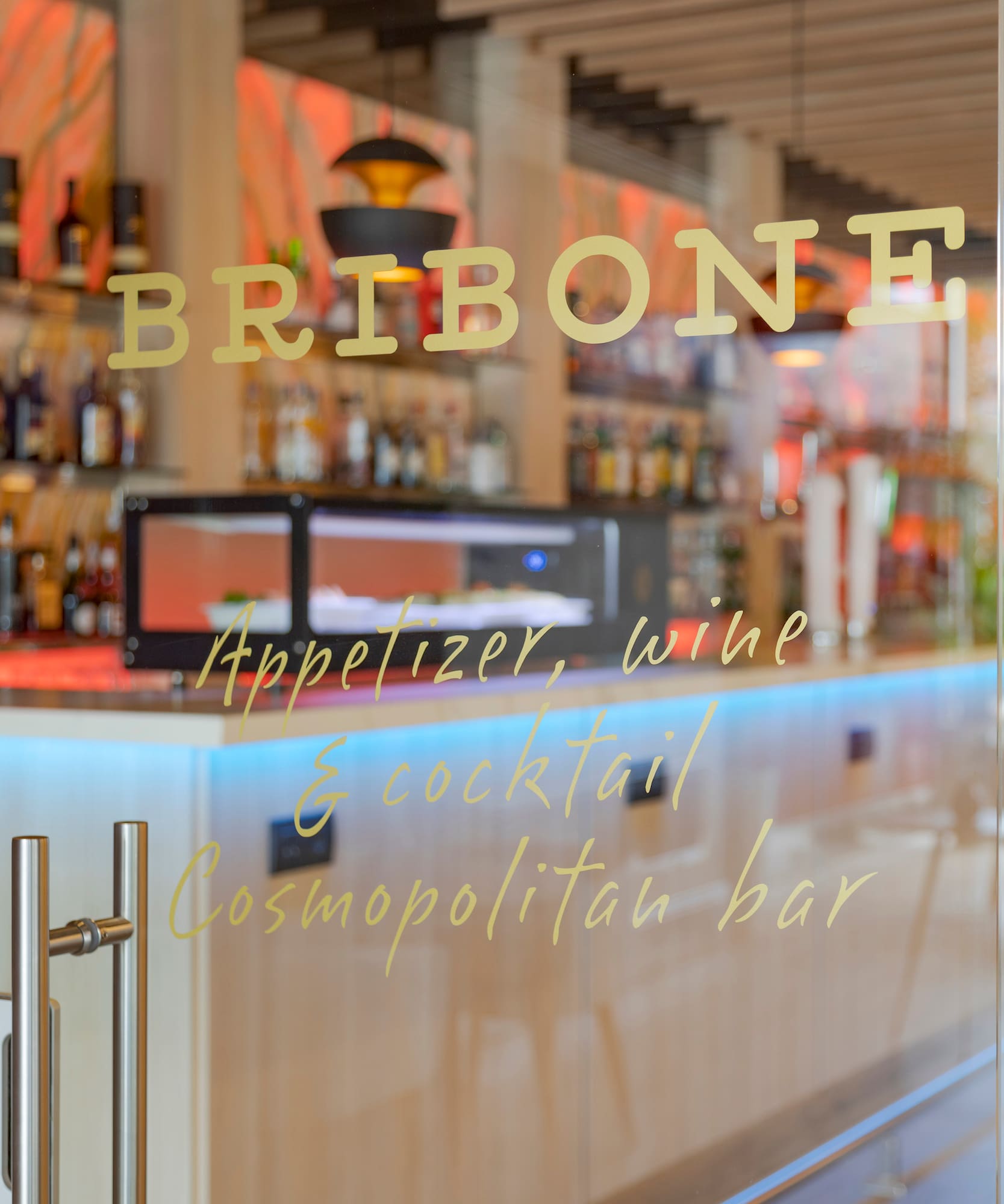 a glass door with a bar and shelves behind it