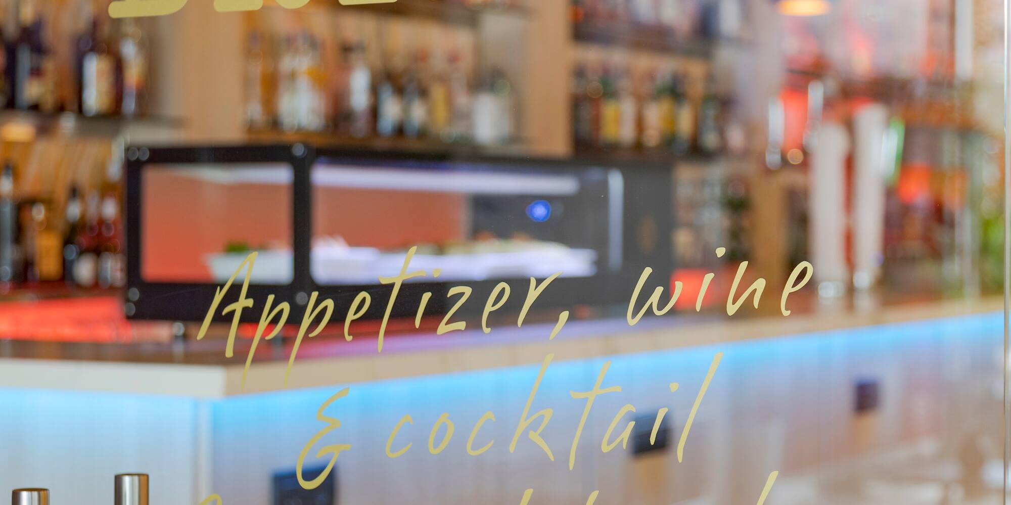 a glass door with a bar and shelves behind it