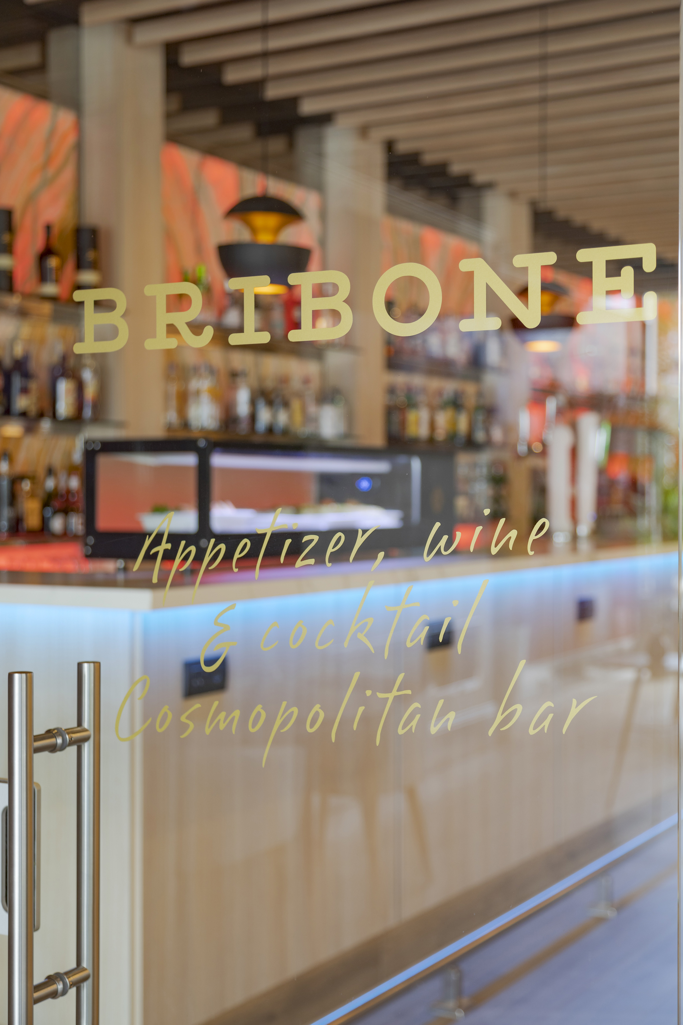 a glass door with a bar and shelves behind it