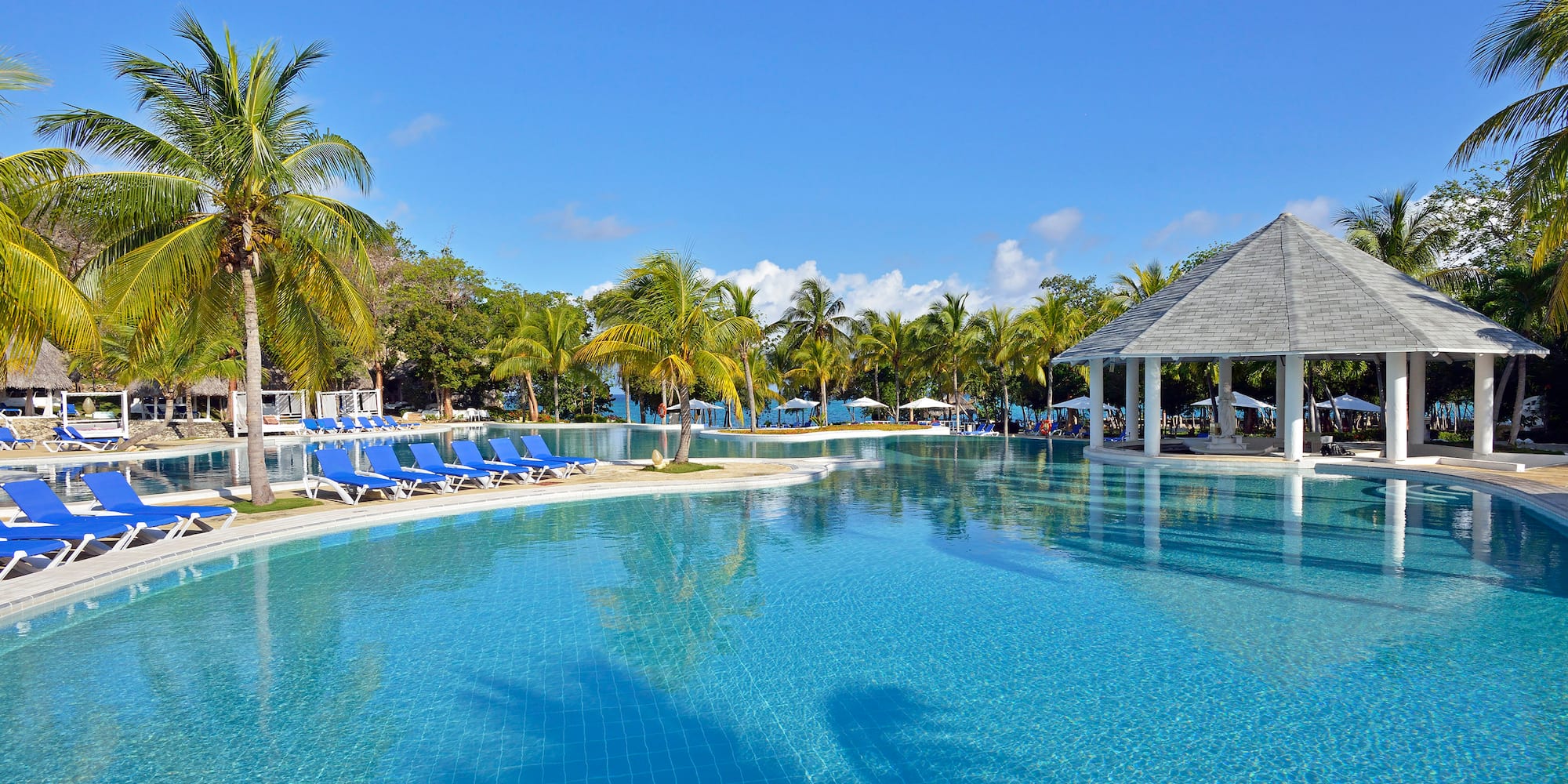 a pool with chairs and a gazebo