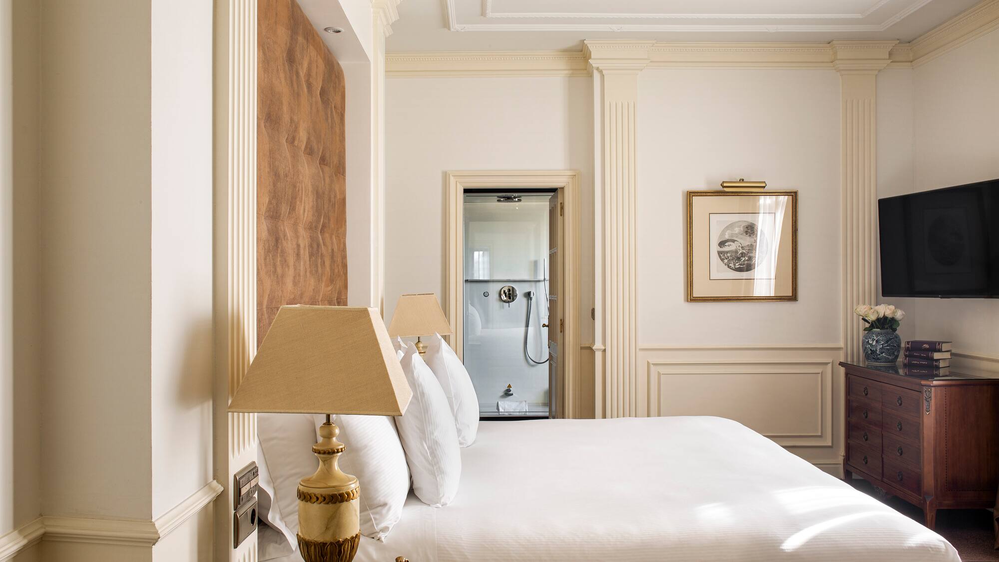 a bed with white sheets and lamps in a room