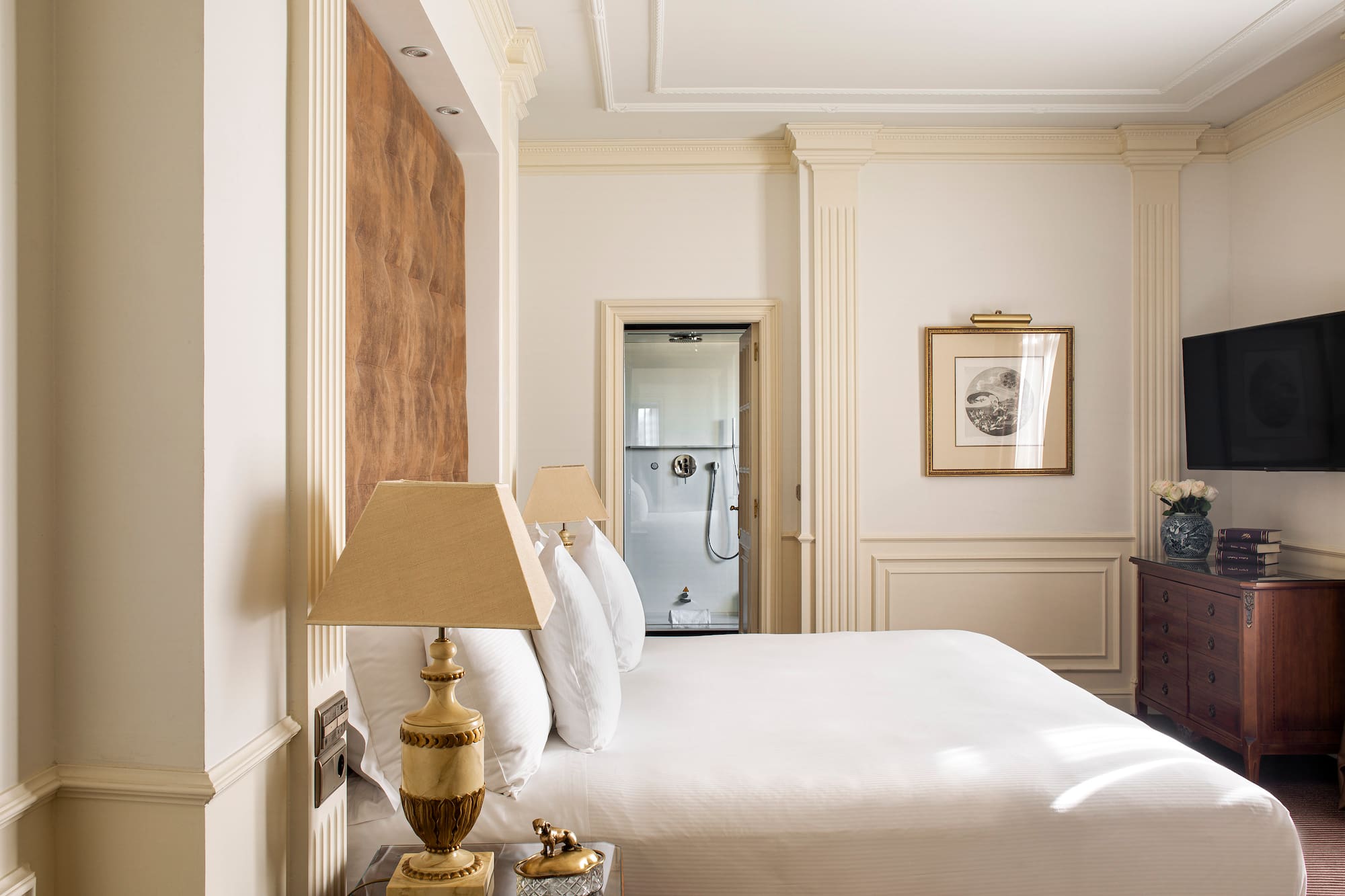 a bed with white sheets and lamps in a room