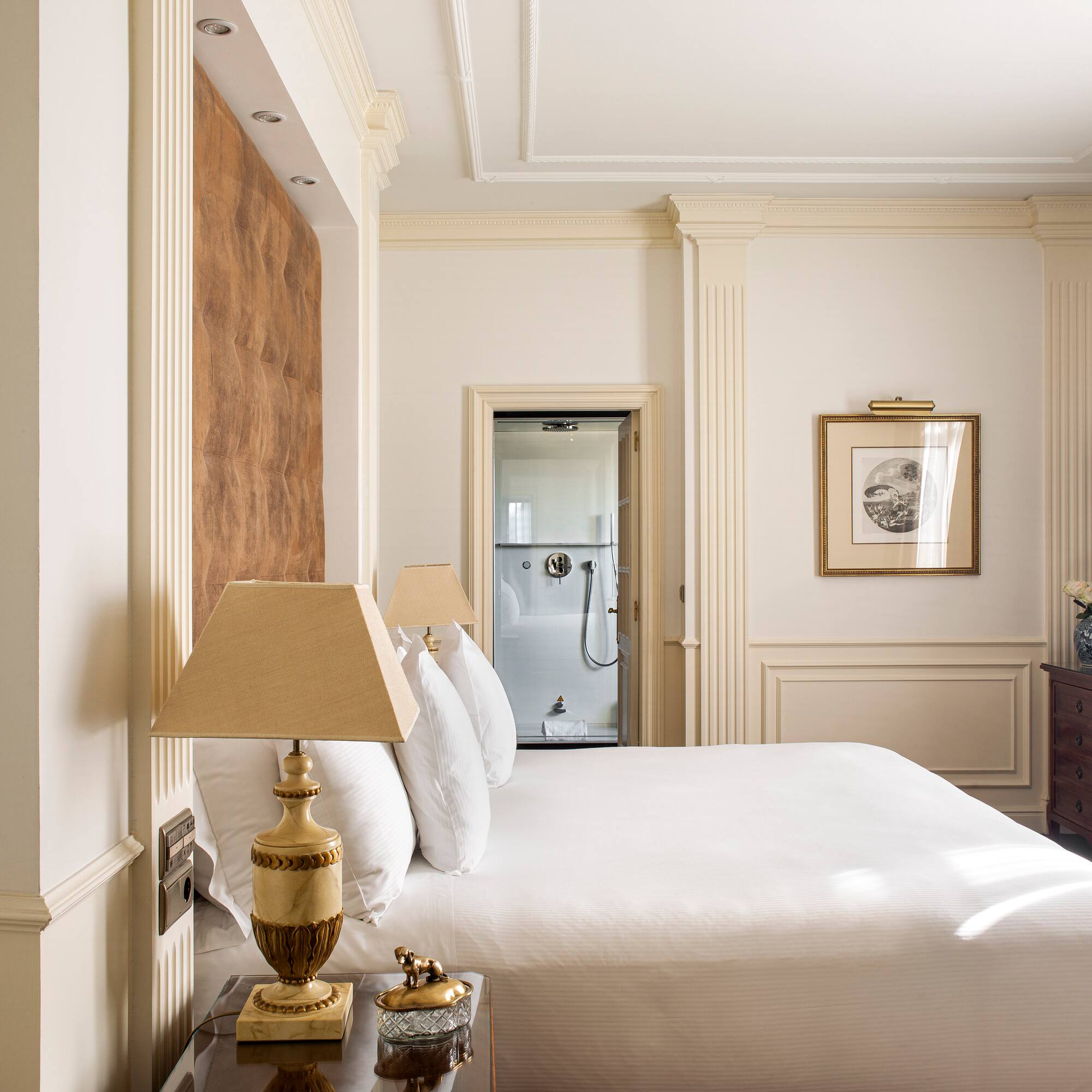 a bed with white sheets and lamps in a room