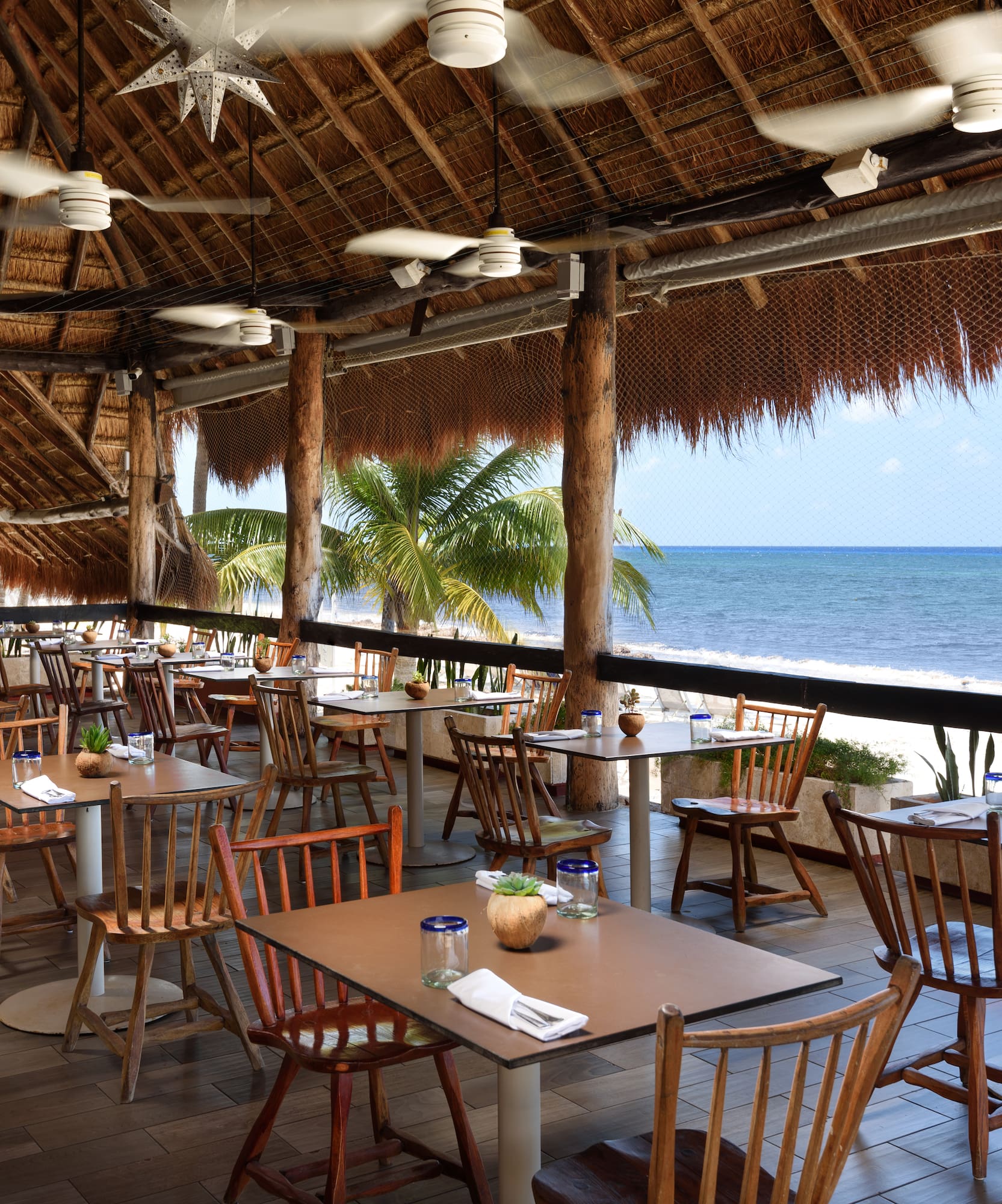 a restaurant with tables and chairs on a beach