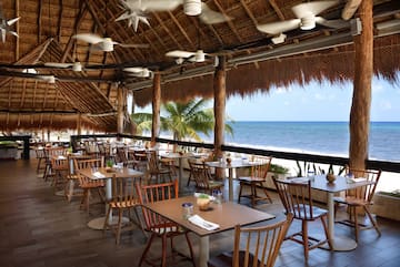 a restaurant with tables and chairs on a beach