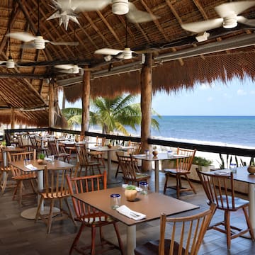 a restaurant with tables and chairs on a beach