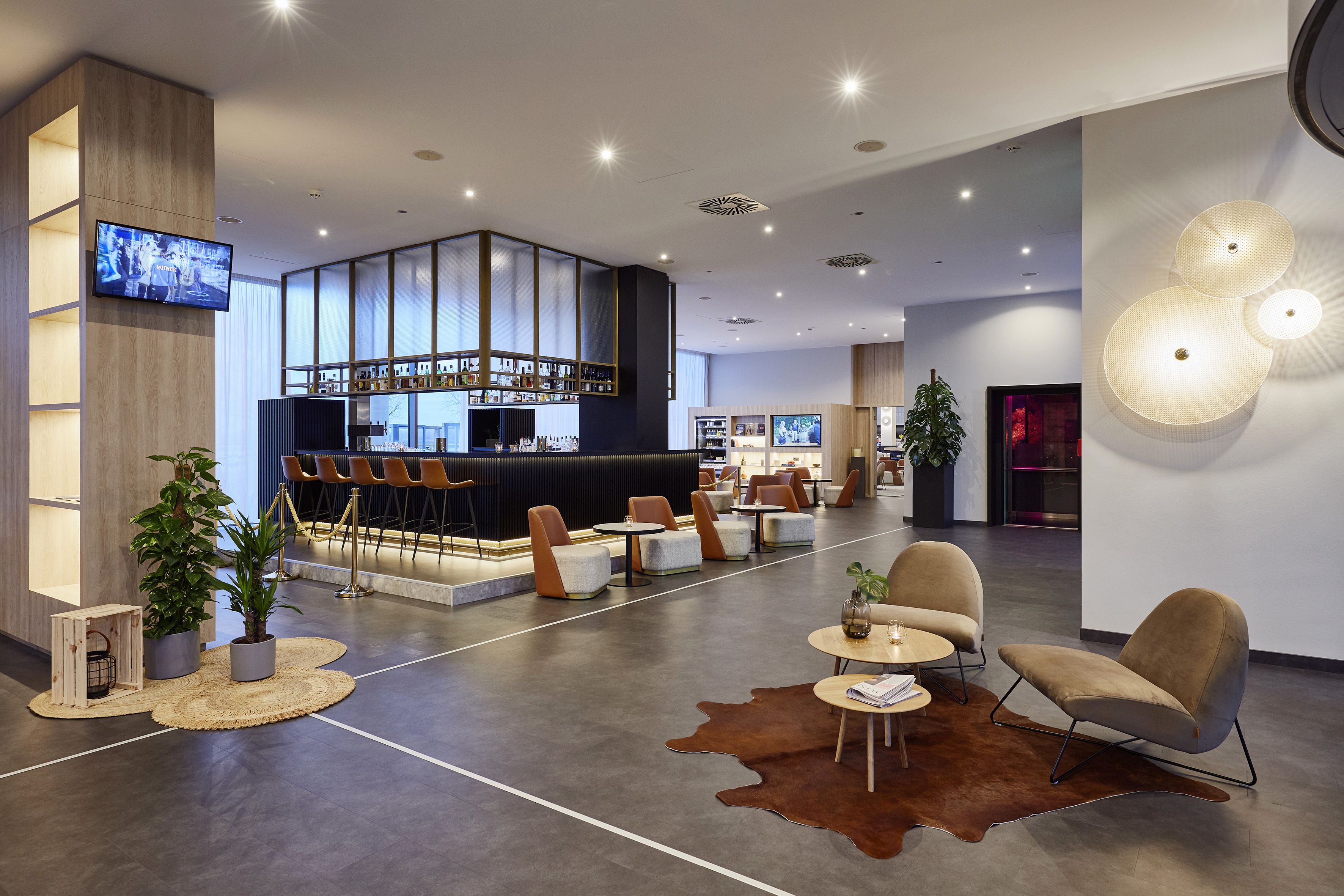 Contemporary hotel lobby bar, lounge seating, and stylish accent lighting.