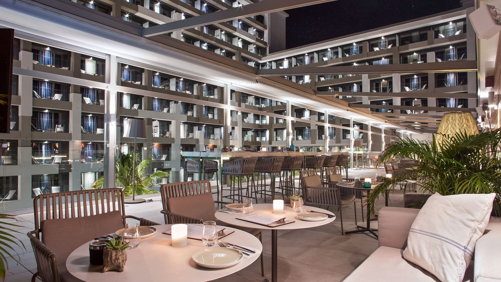 a patio with tables and chairs and a large building