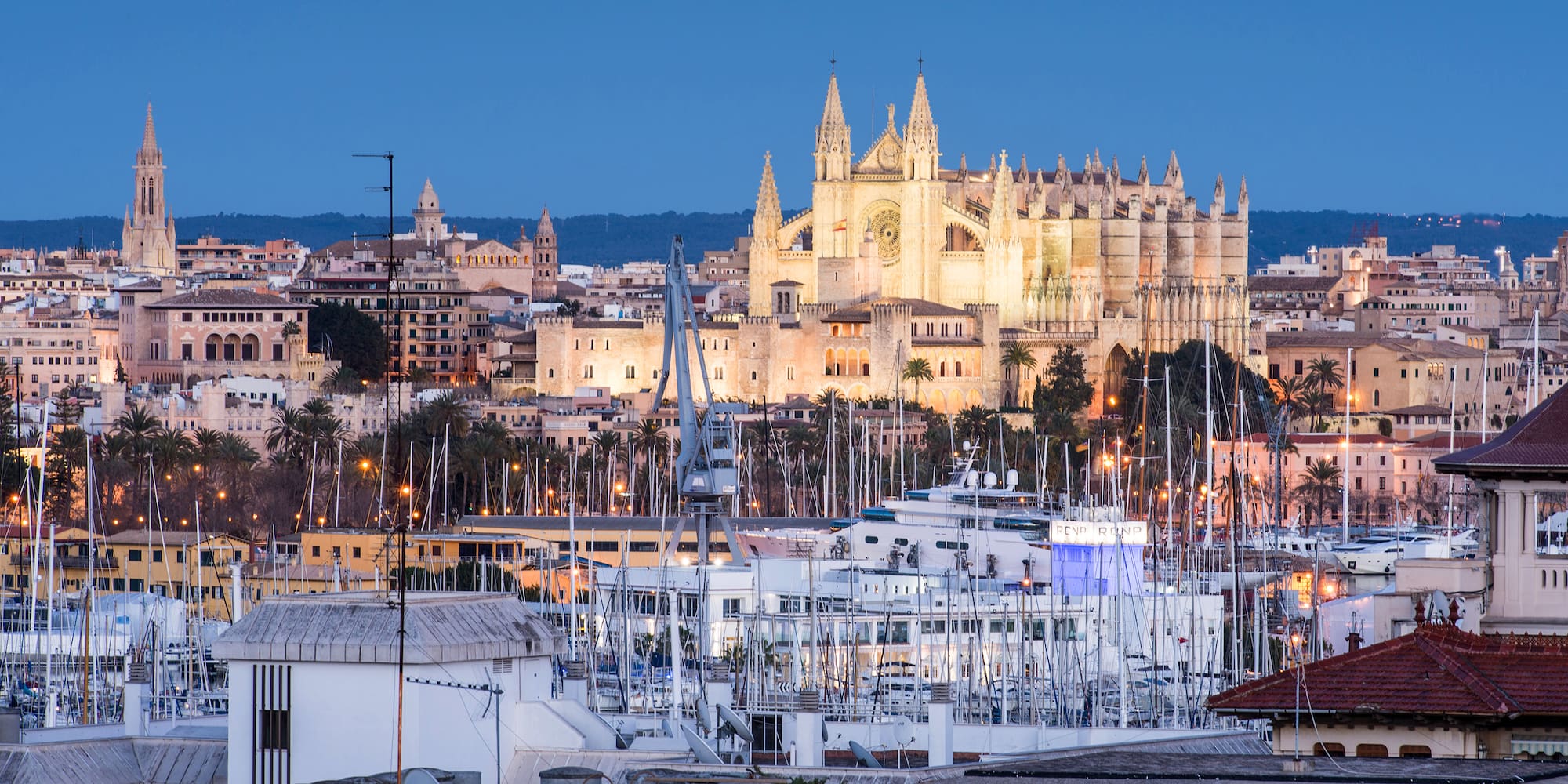 a large castle with many towers and many boats in a harbor