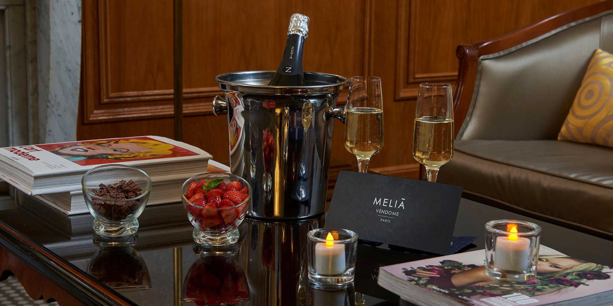 a champagne in a bucket and glasses of wine on a table