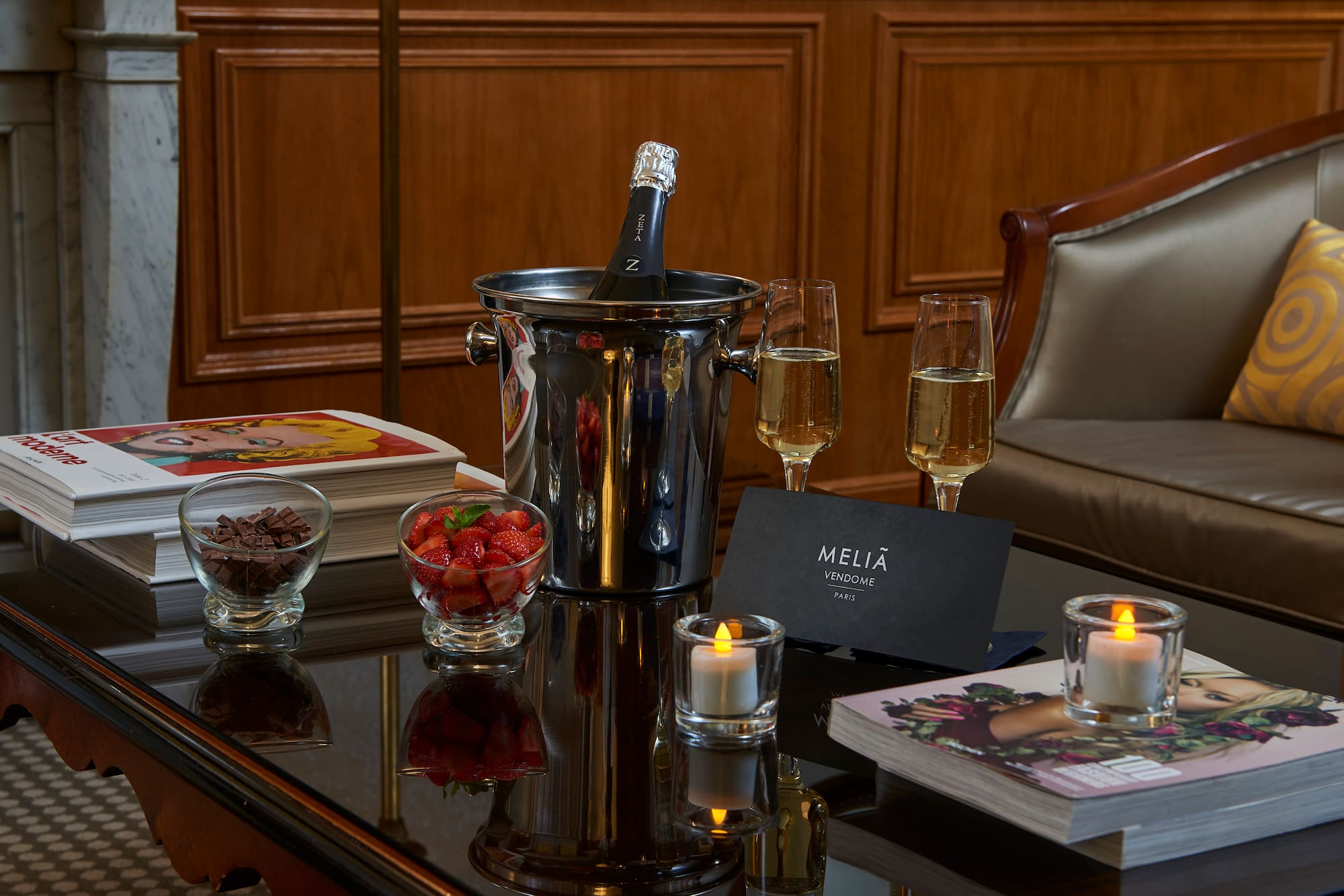 a champagne in a bucket and glasses of wine on a table