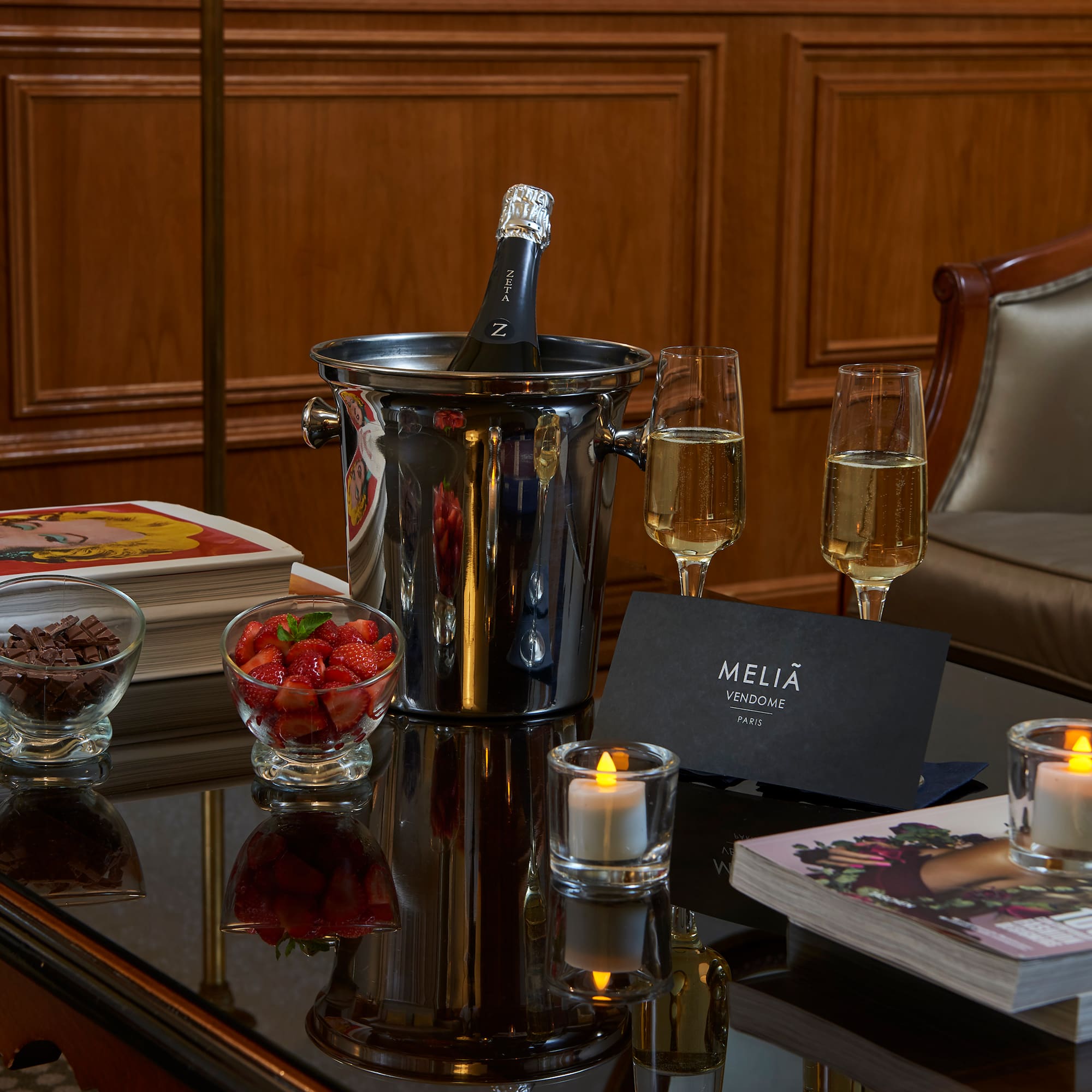 a champagne in a bucket and glasses of wine on a table