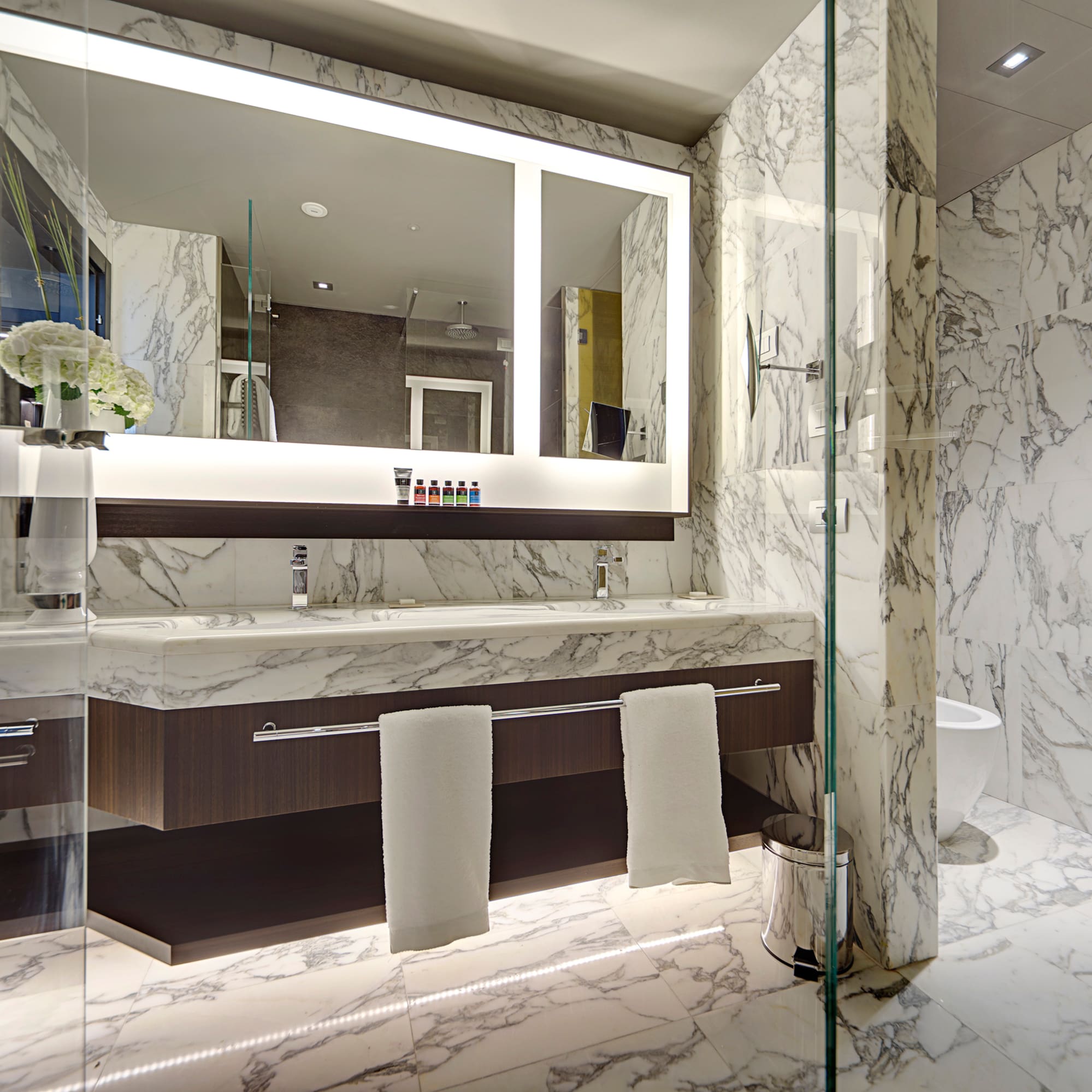 a bathroom with marble walls and a mirror