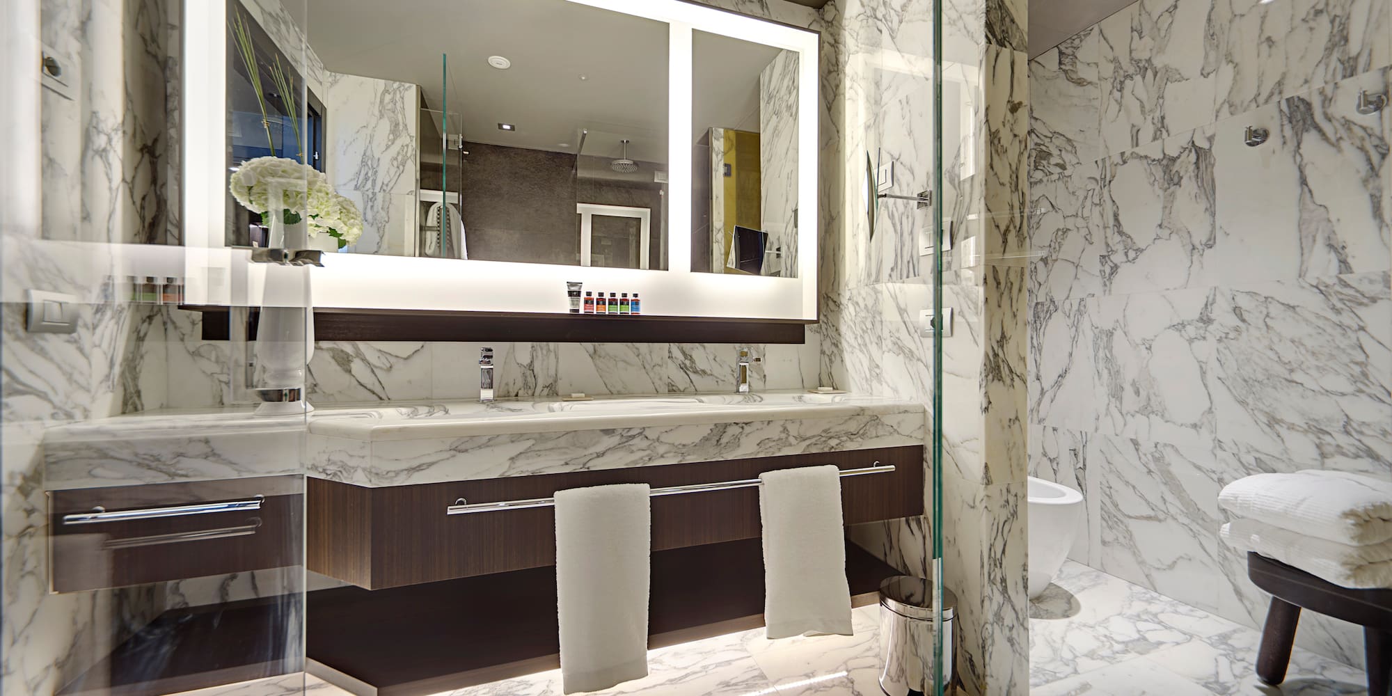 a bathroom with marble walls and a mirror