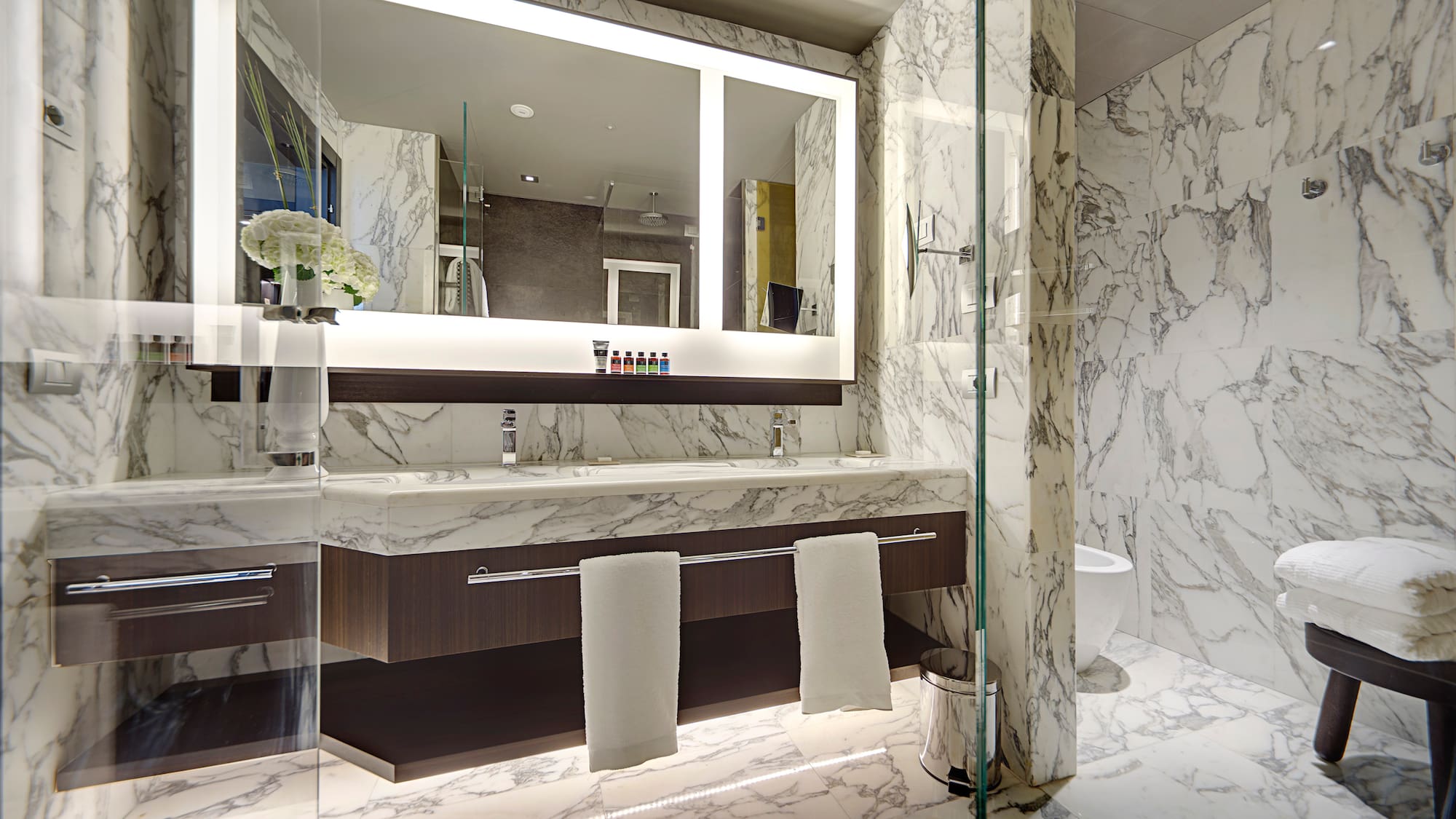 a bathroom with marble walls and a mirror