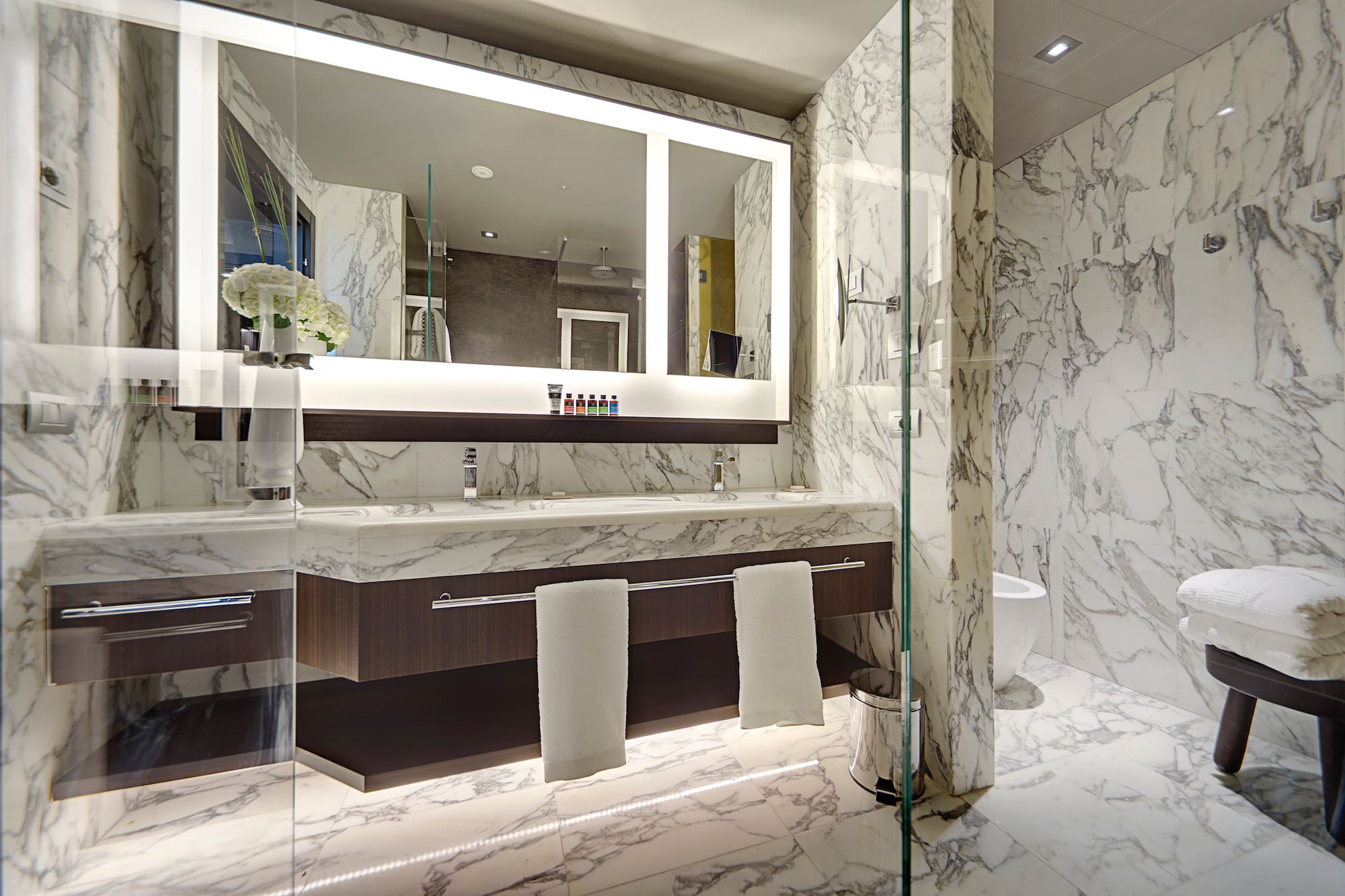 a bathroom with marble walls and a mirror