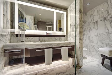 a bathroom with marble walls and a mirror