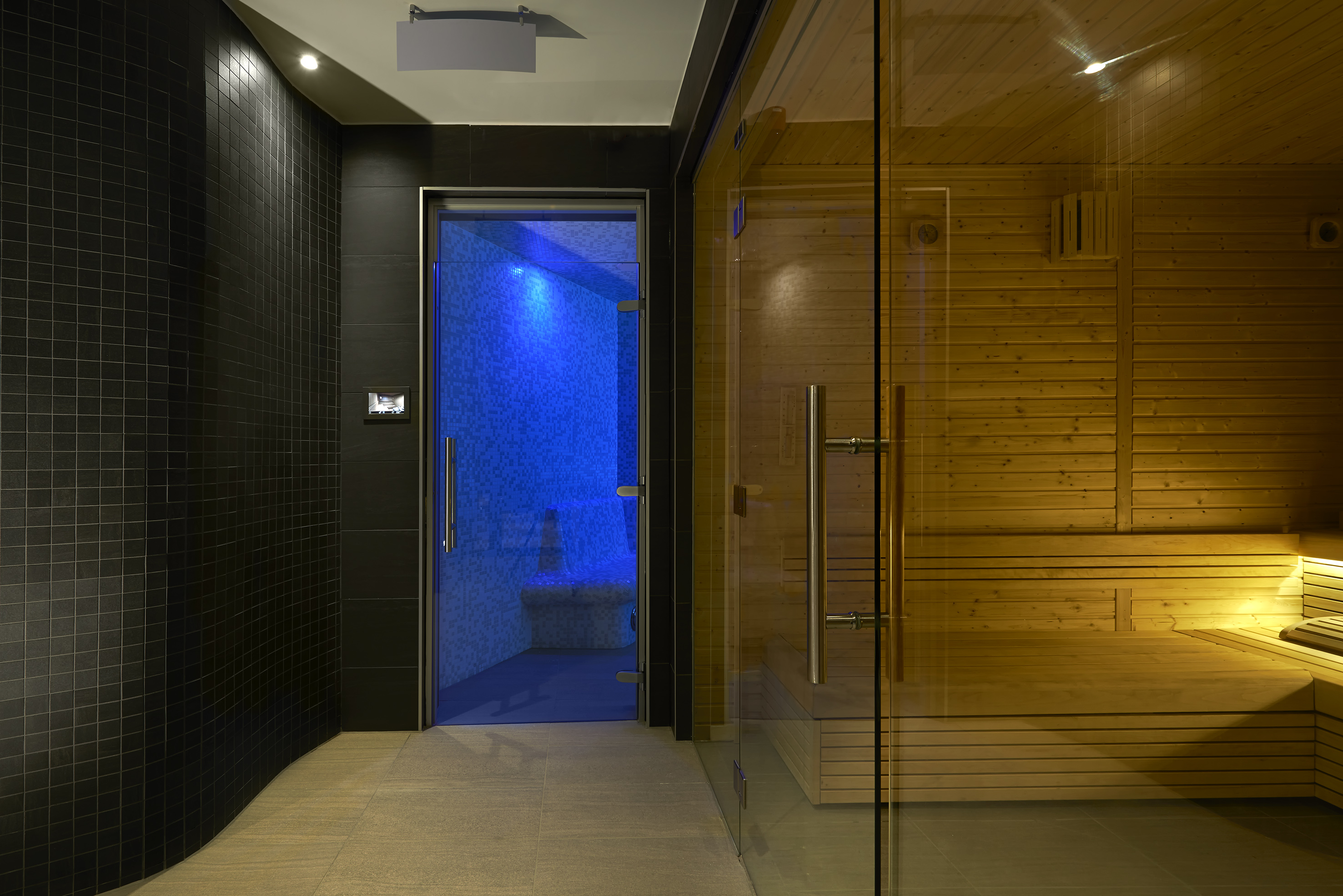 a sauna with a glass door and a wooden bench